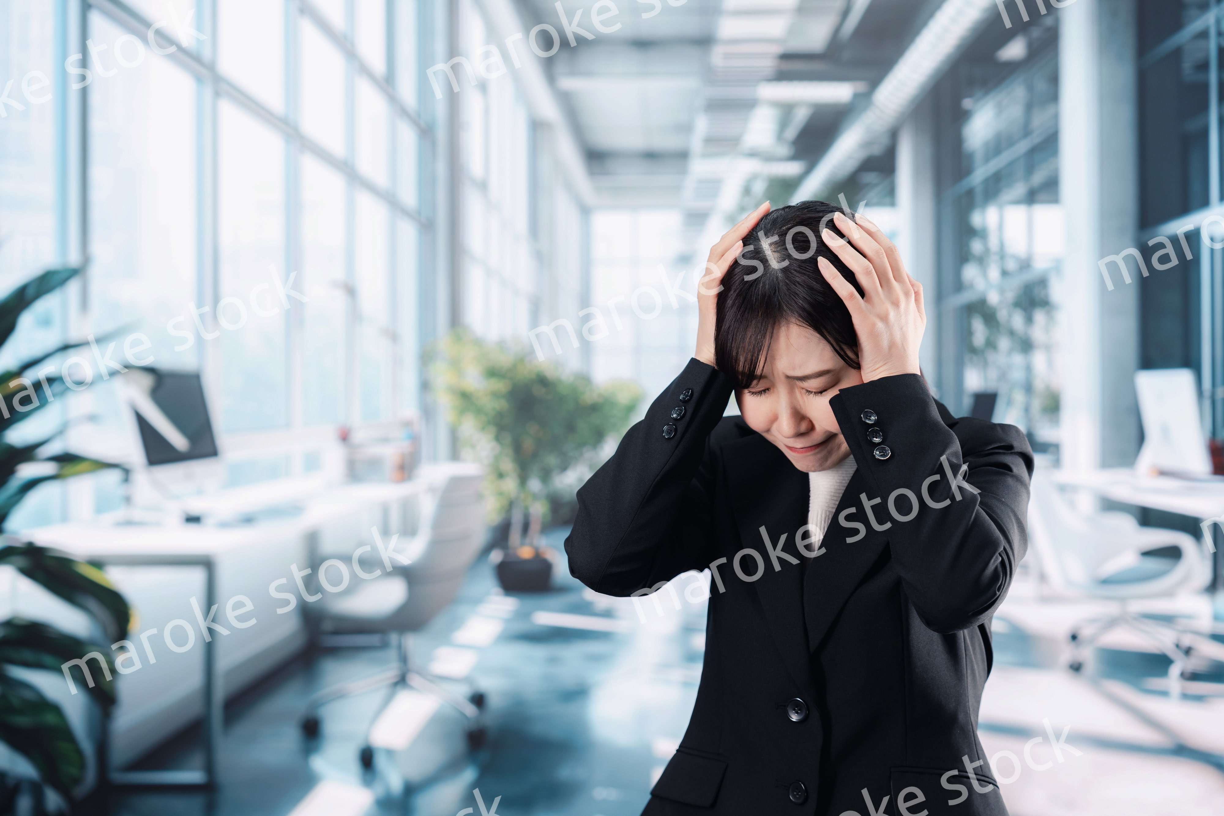 オフィスで頭を抱えるビジネスウーマン
