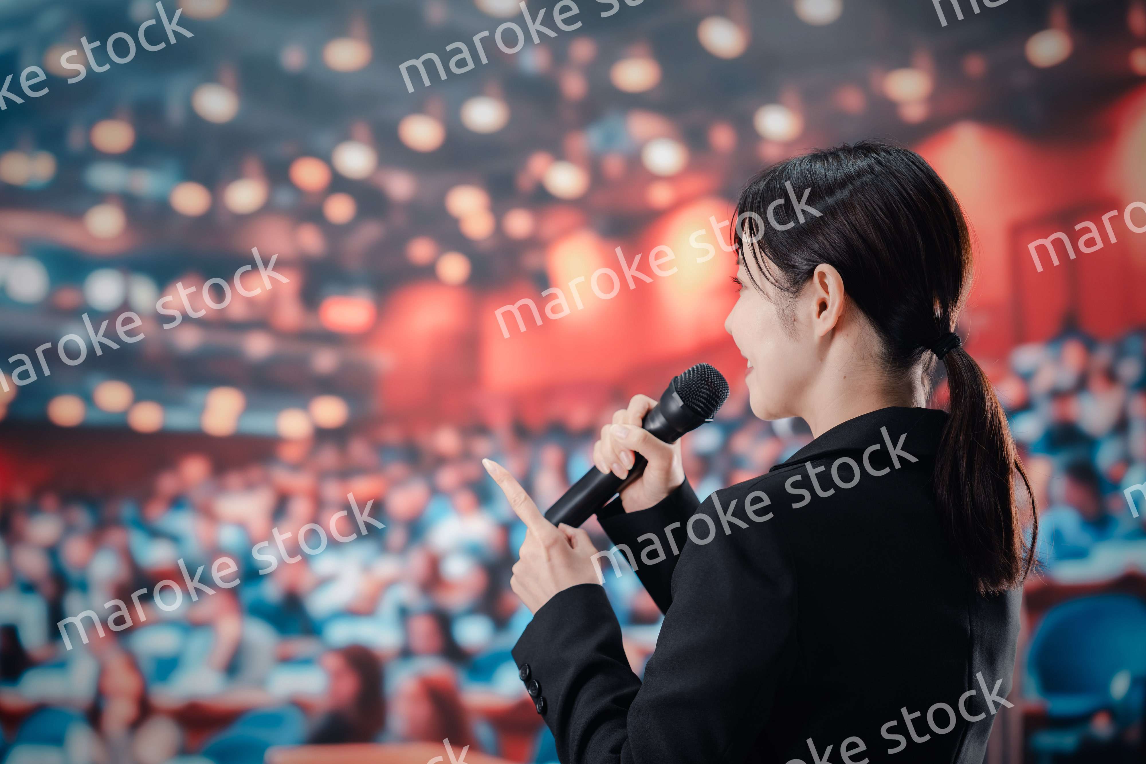 大勢の聴衆の前でスピーチをする女性