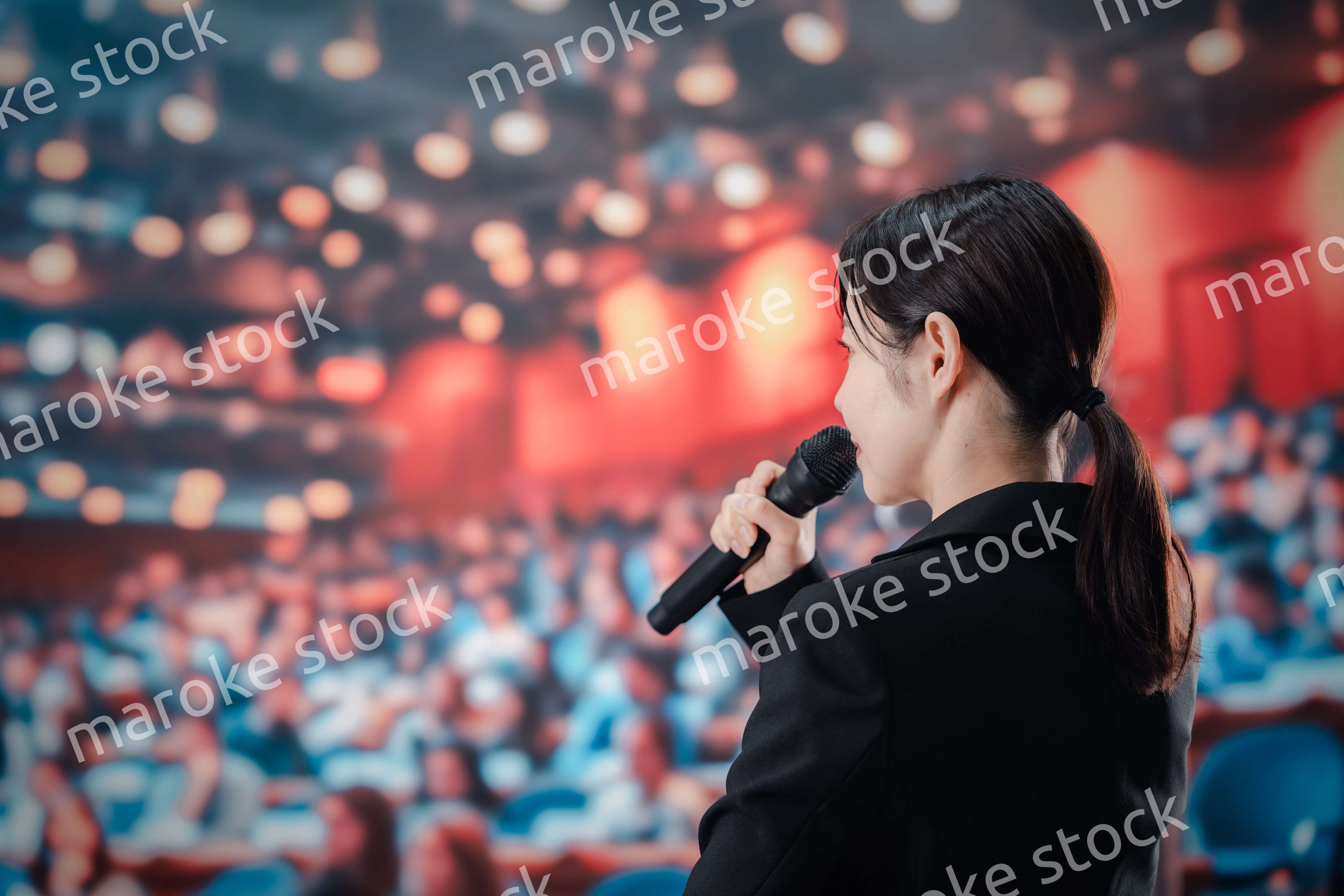 大勢の聴衆の前でスピーチをする女性