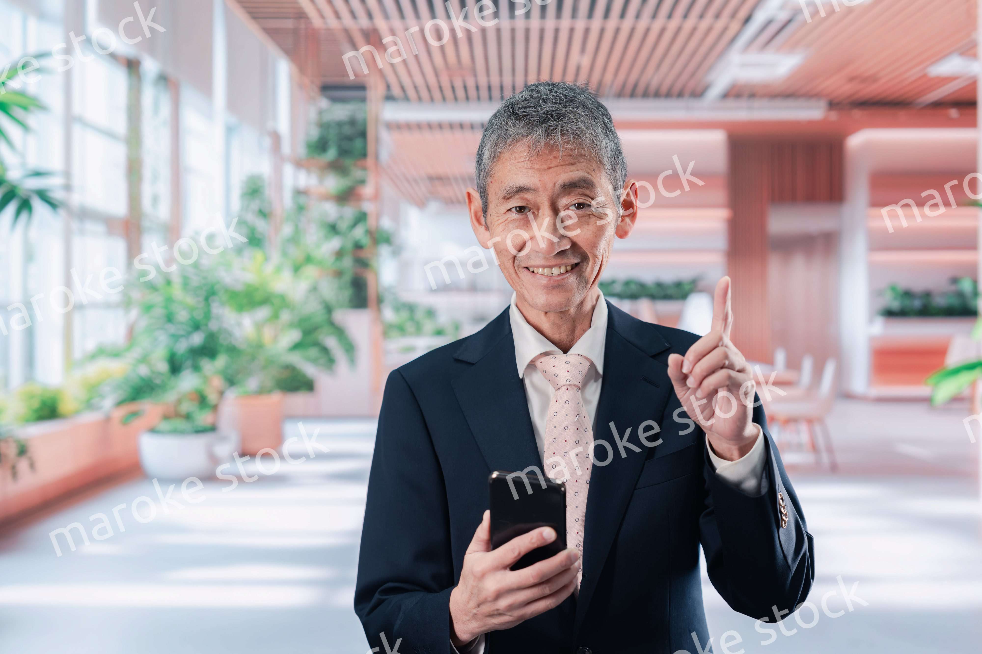 笑顔でスマホを使う中年のビジネスマン