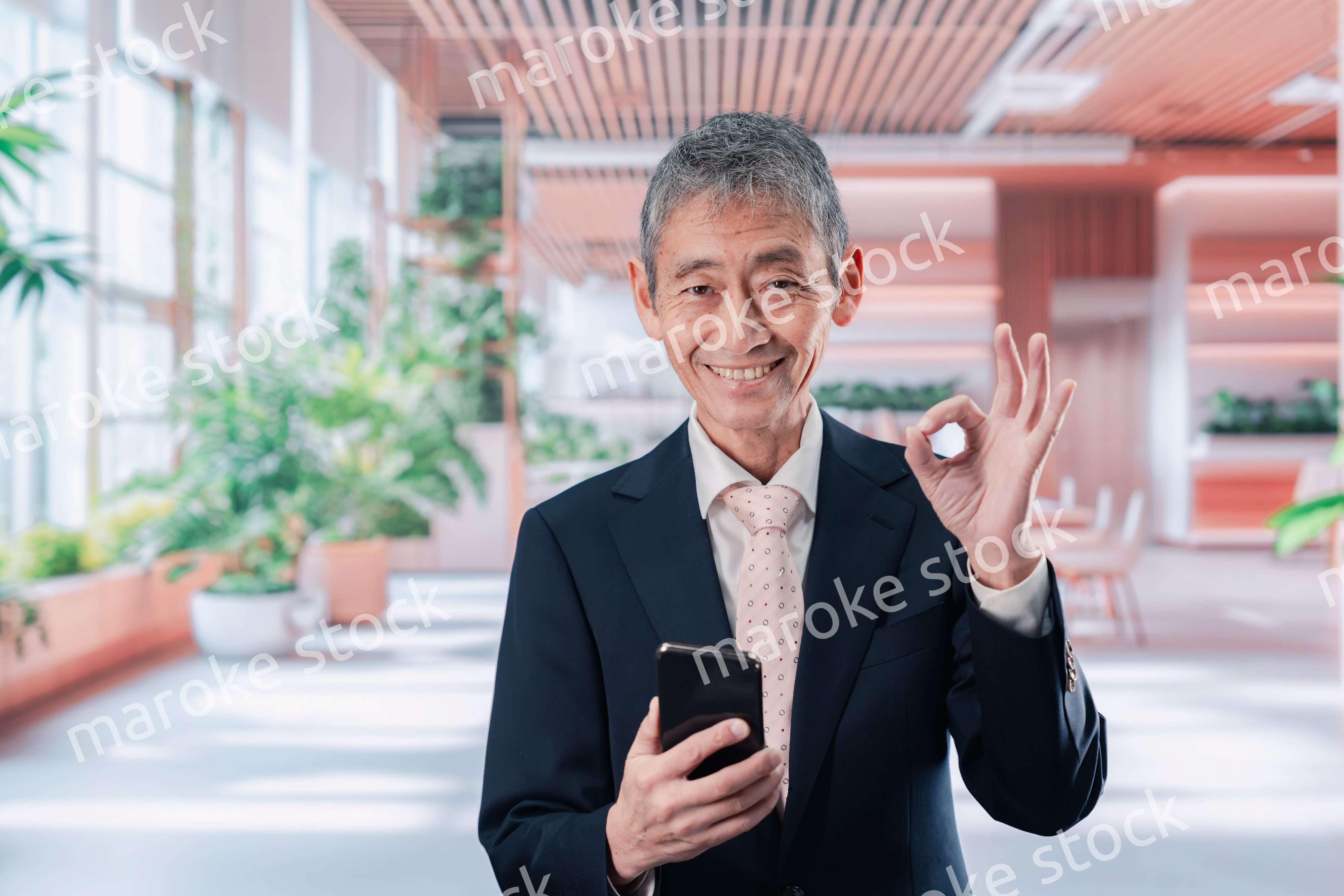 笑顔でスマホを使う中年のビジネスマン