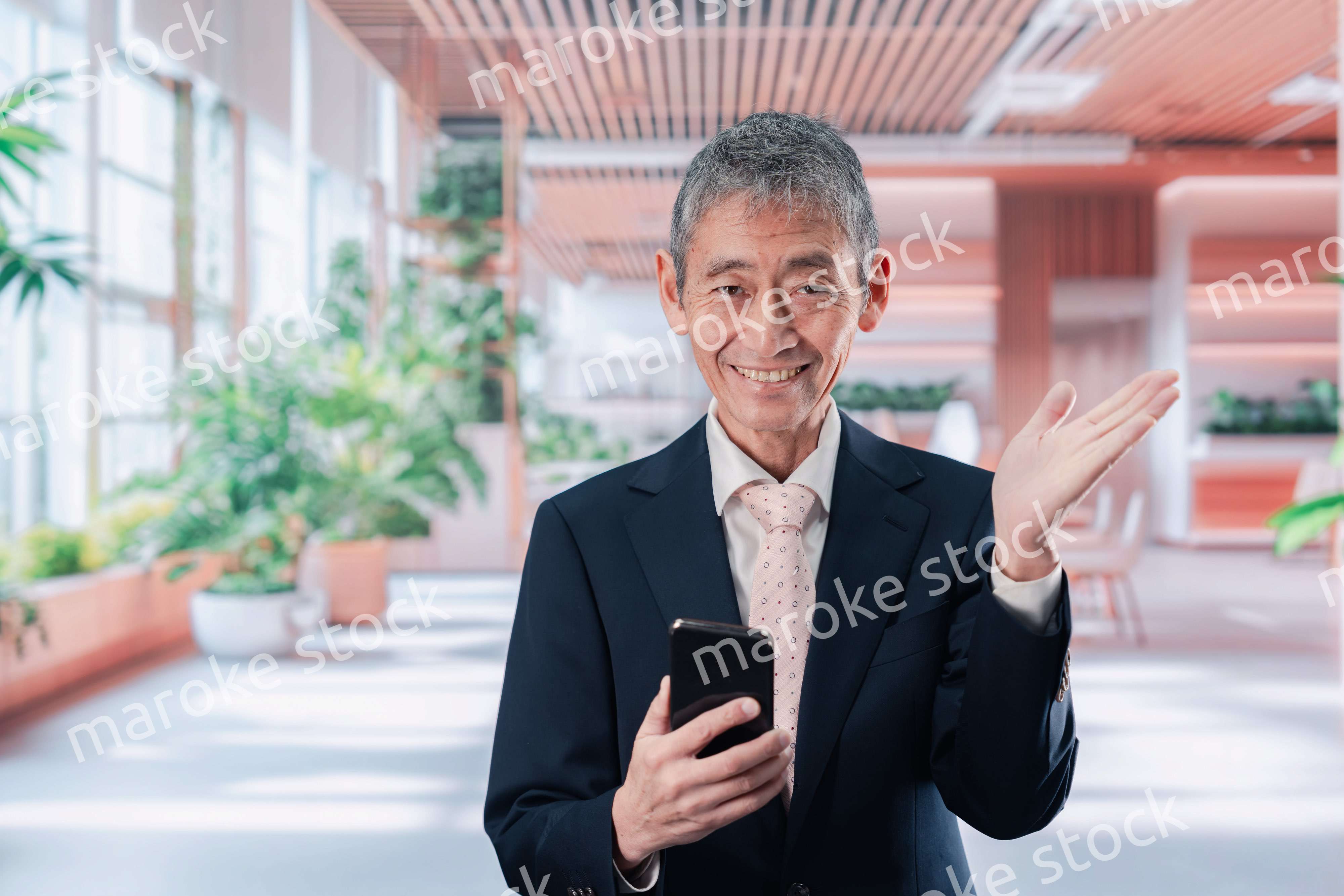 笑顔でスマホを使う中年のビジネスマン