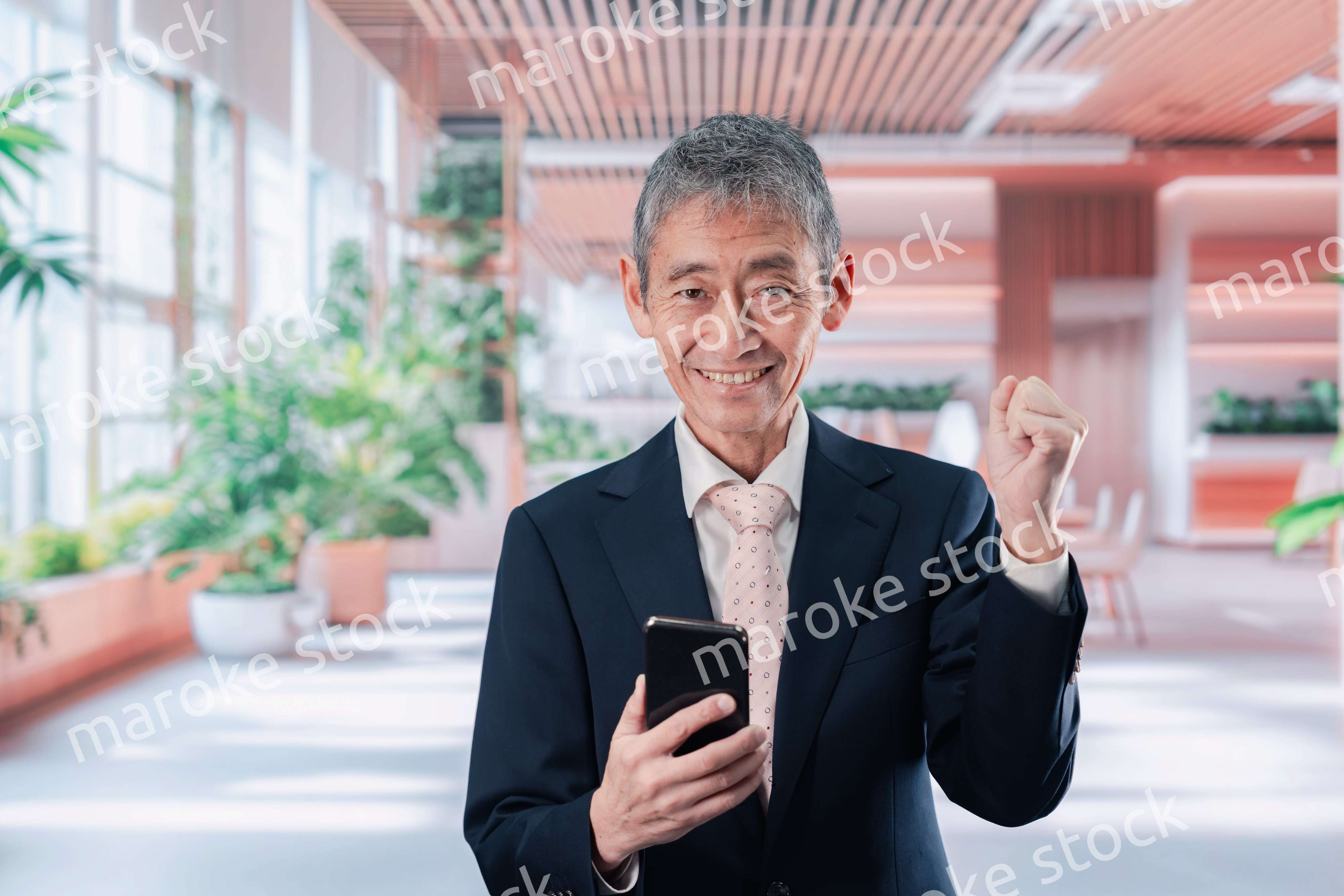 笑顔でスマホを使う中年のビジネスマン