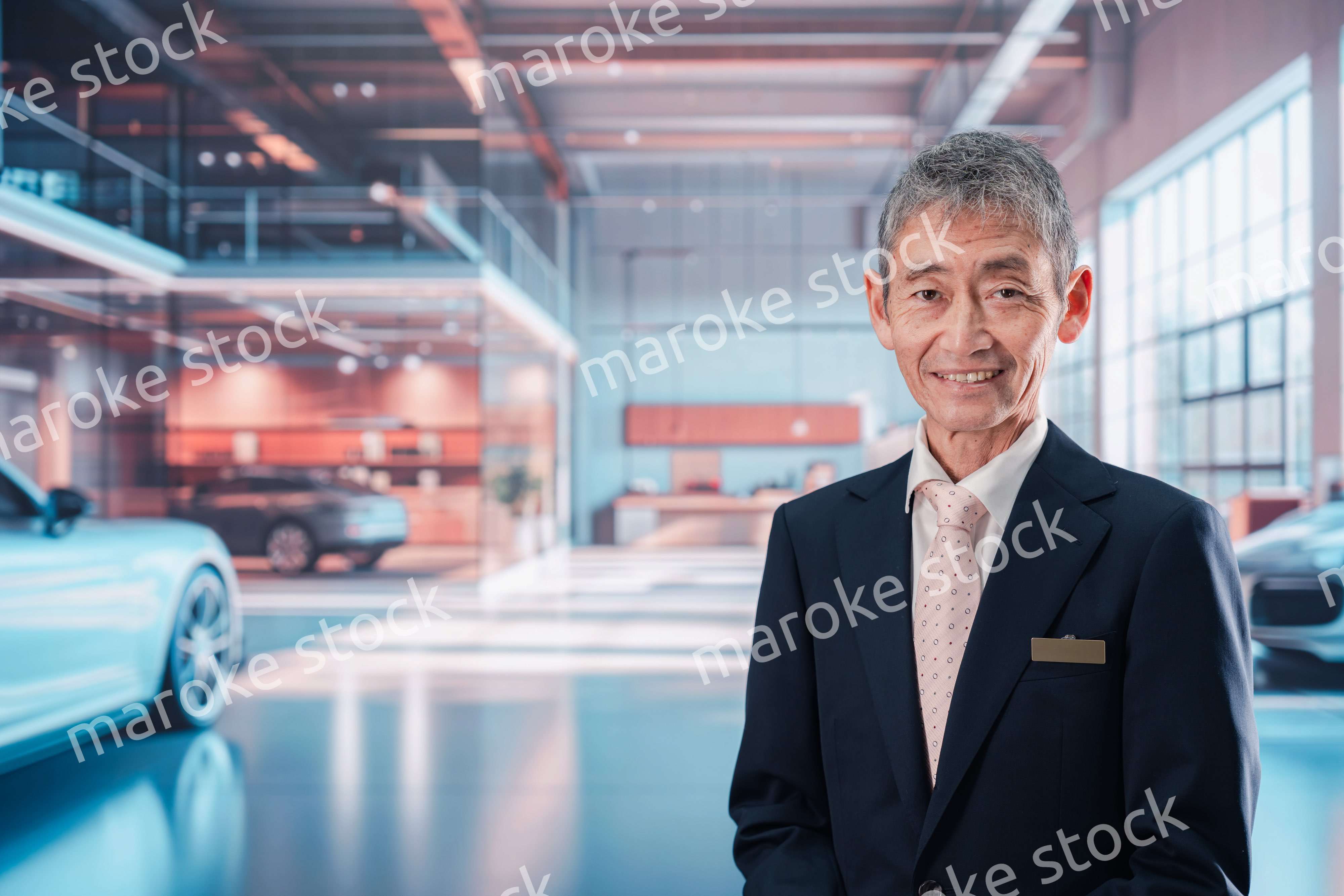 カーディーラーで接客をする男性