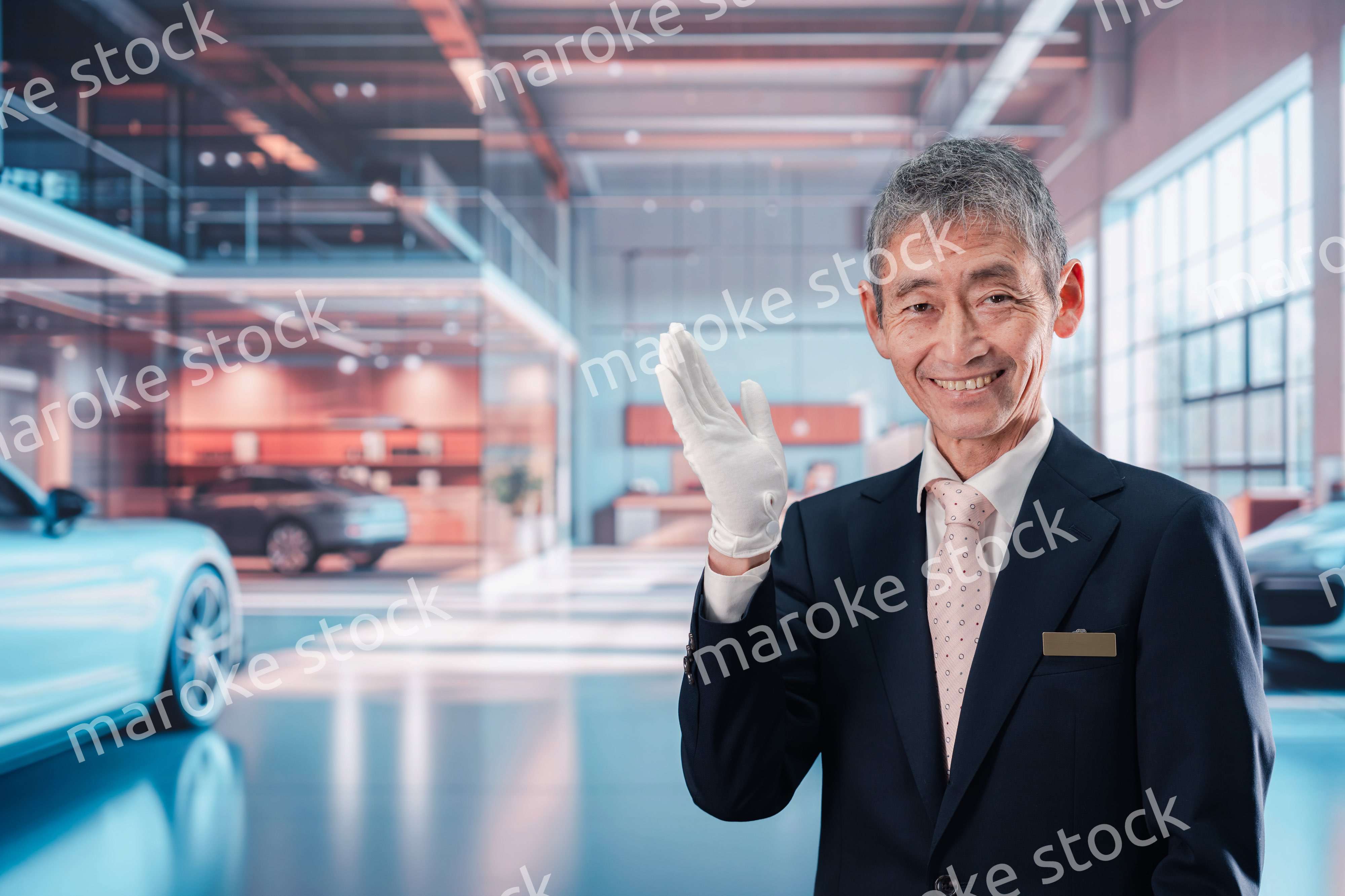 カーディーラーで接客をする男性