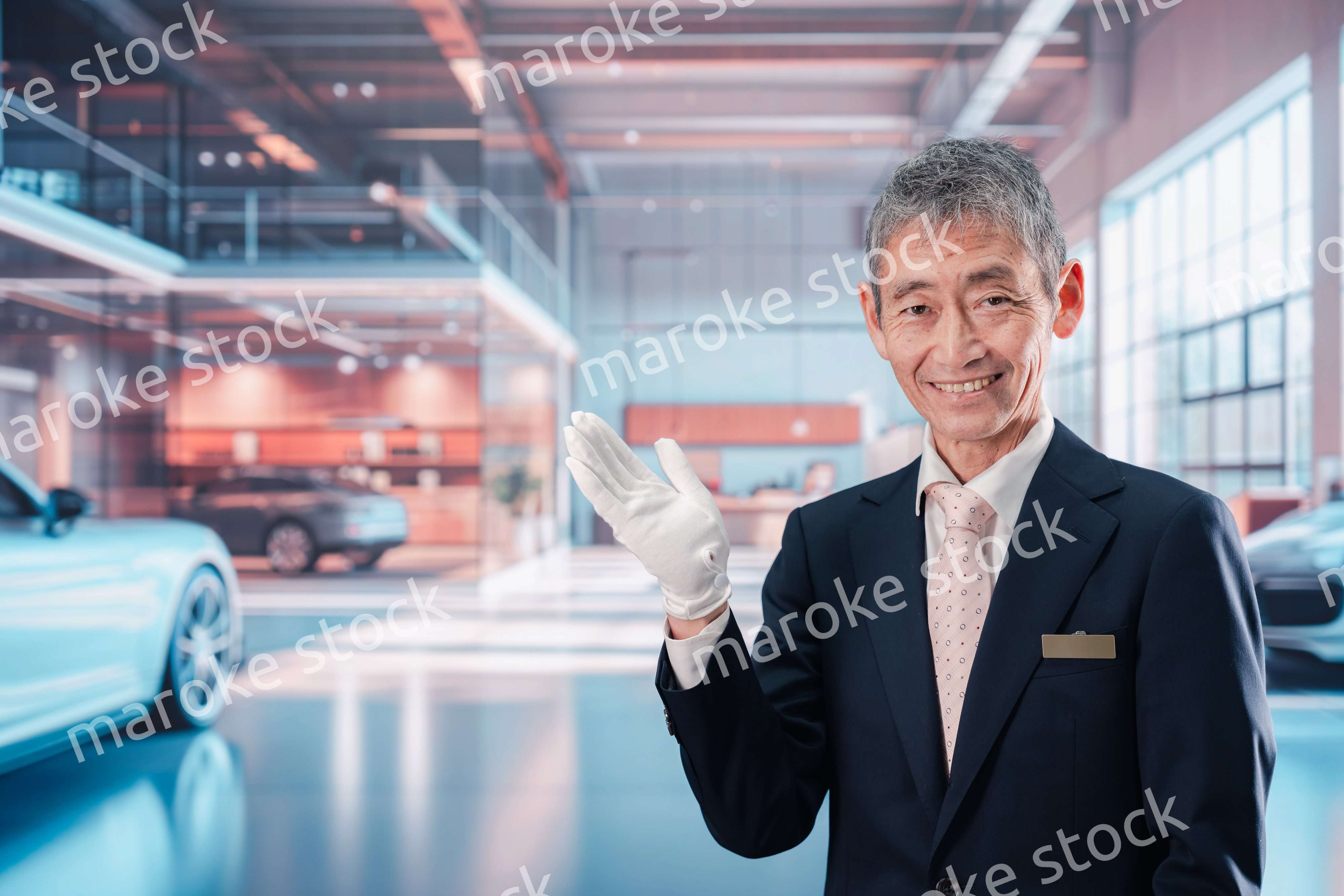 カーディーラーで接客をする男性