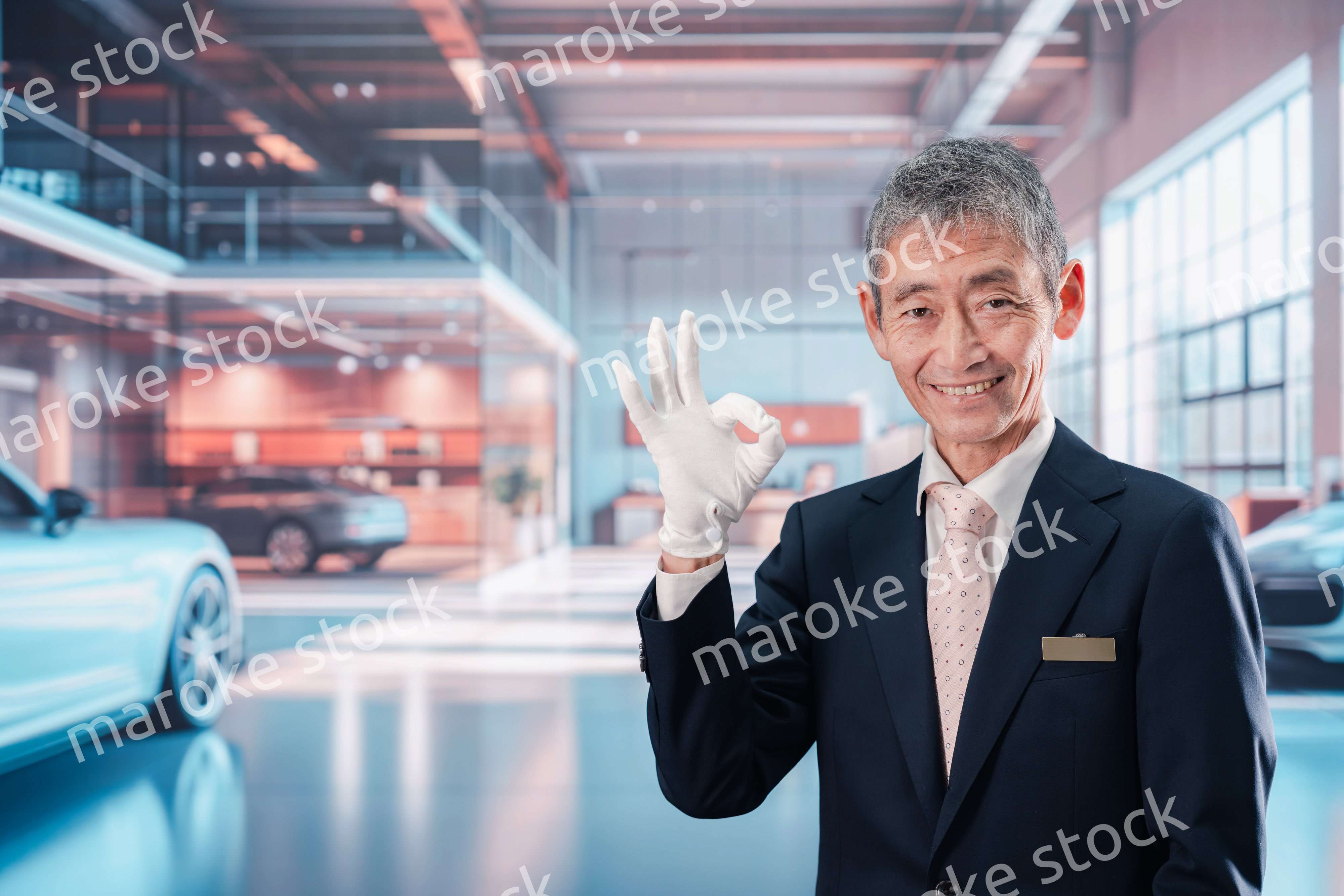 カーディーラーで接客をする男性