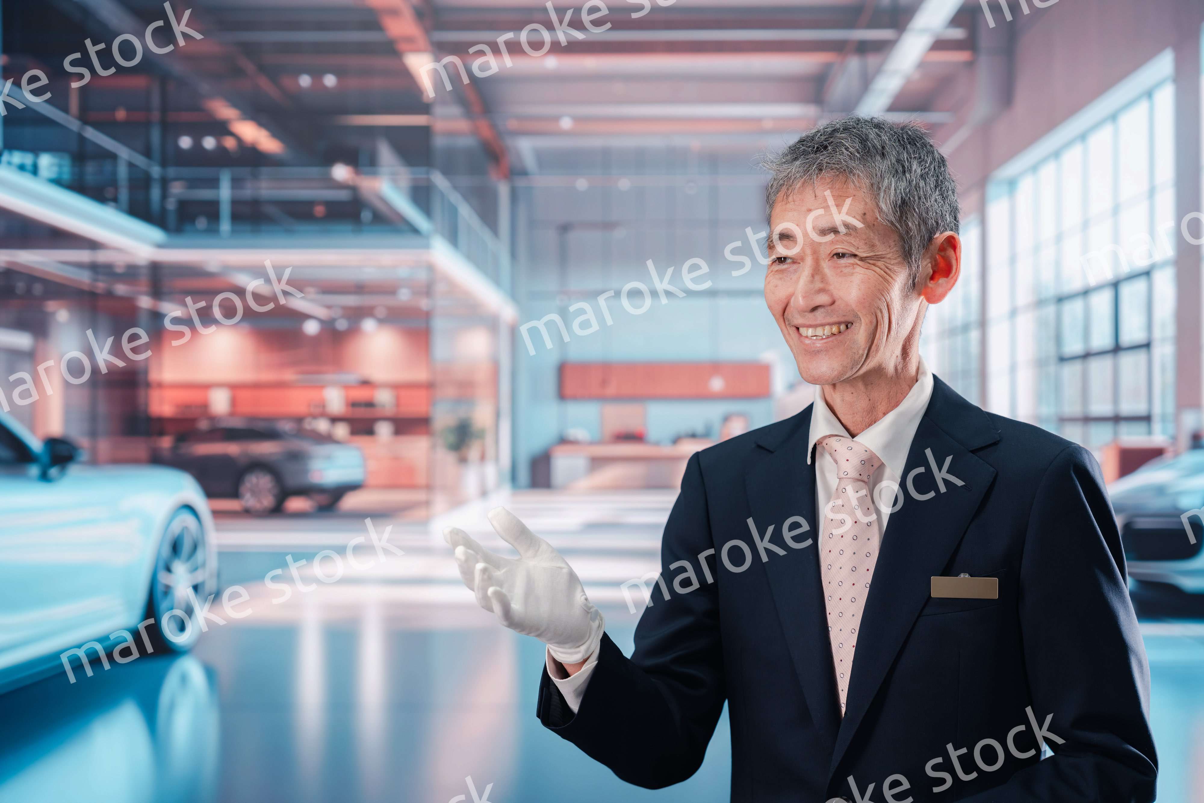 カーディーラーで接客をする男性