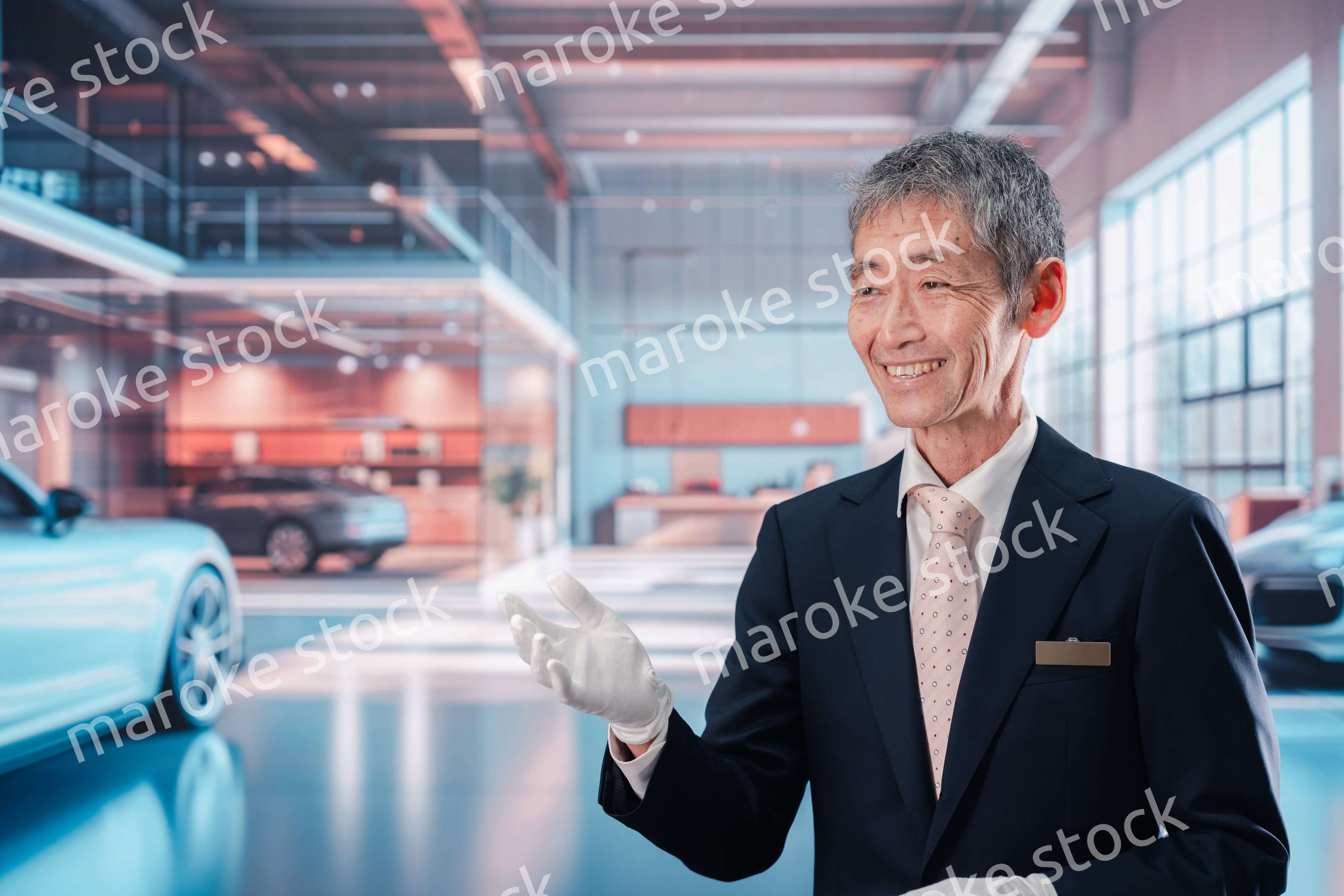 カーディーラーで接客をする男性