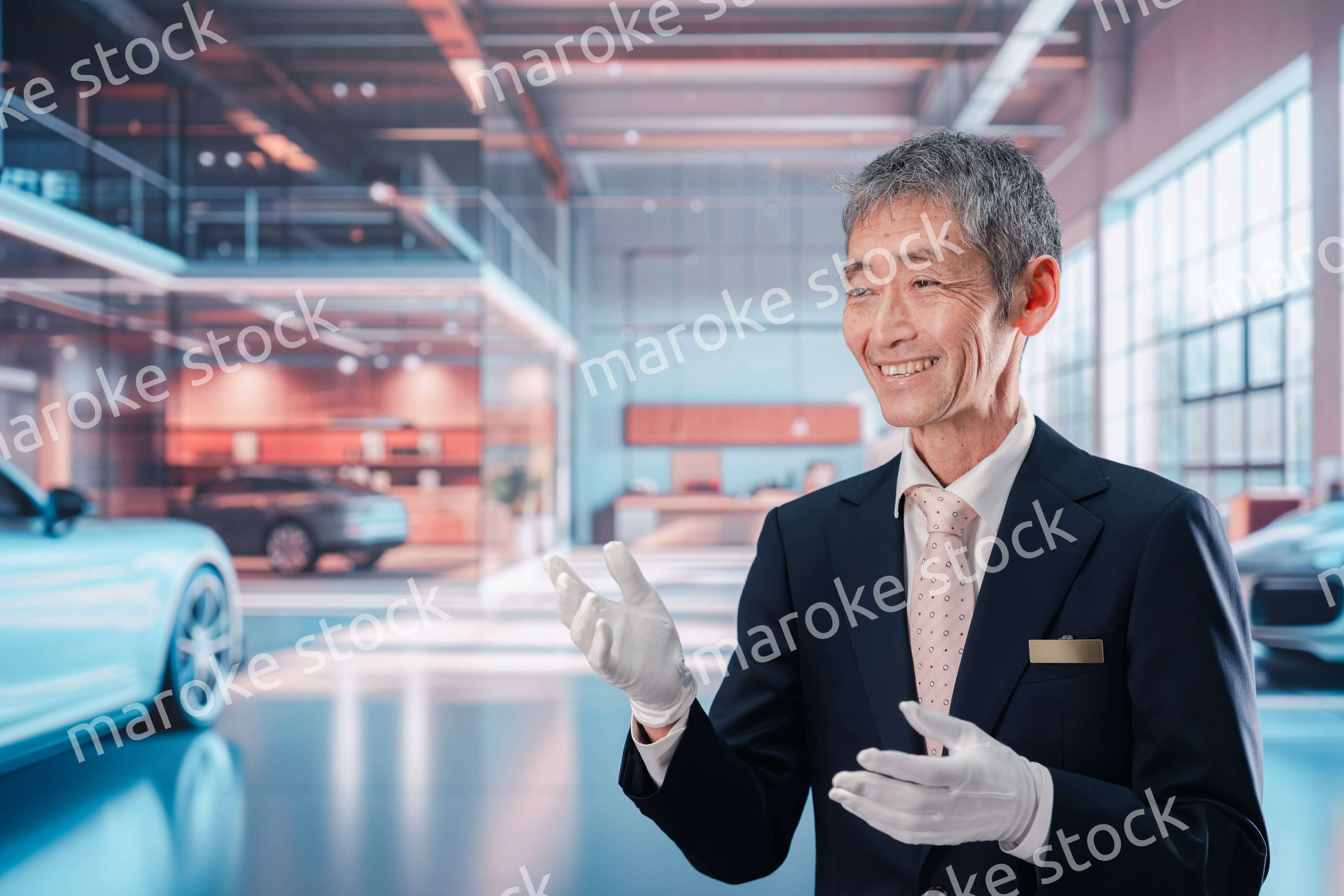 カーディーラーで接客をする男性