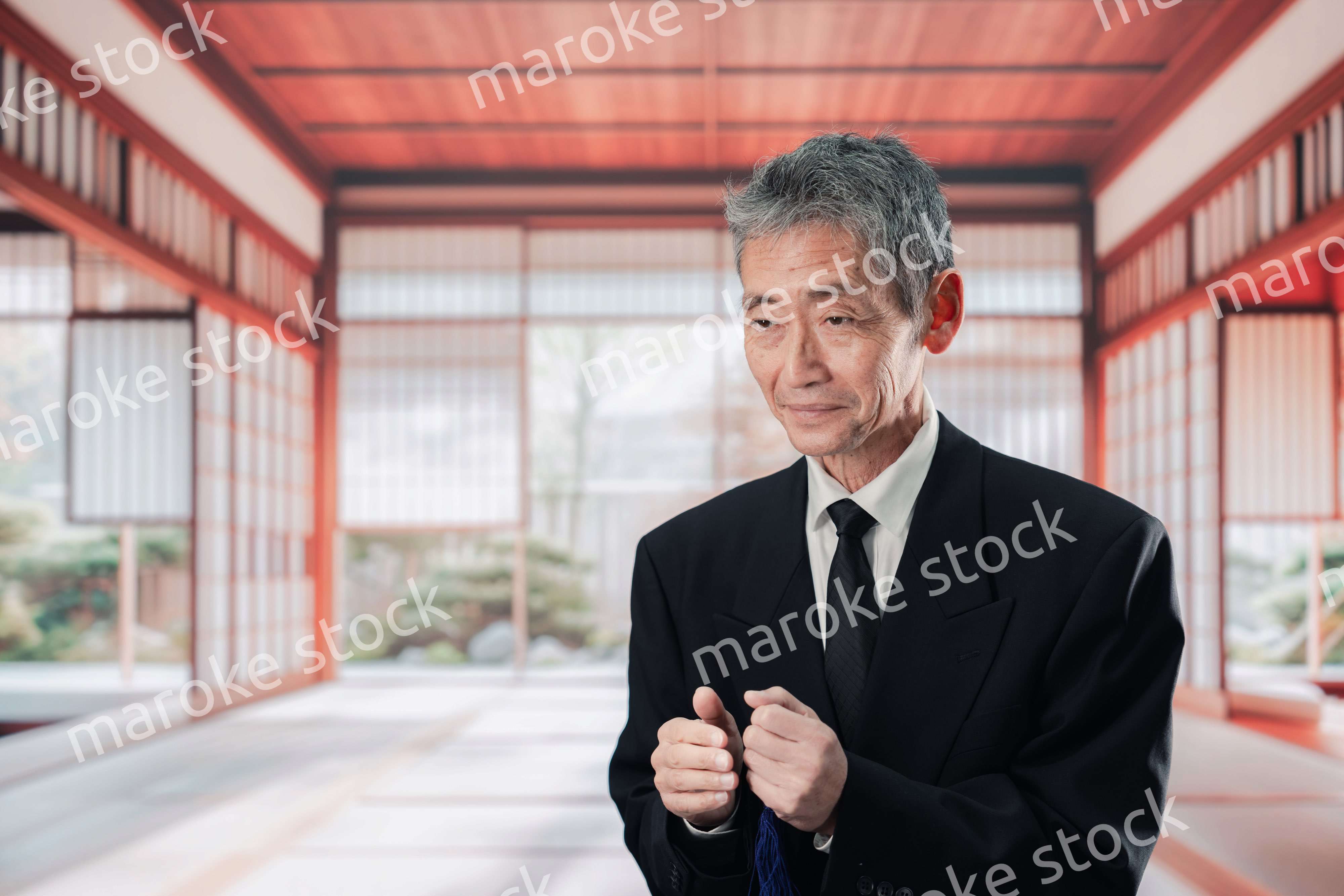 葬儀に参列する高齢の男性