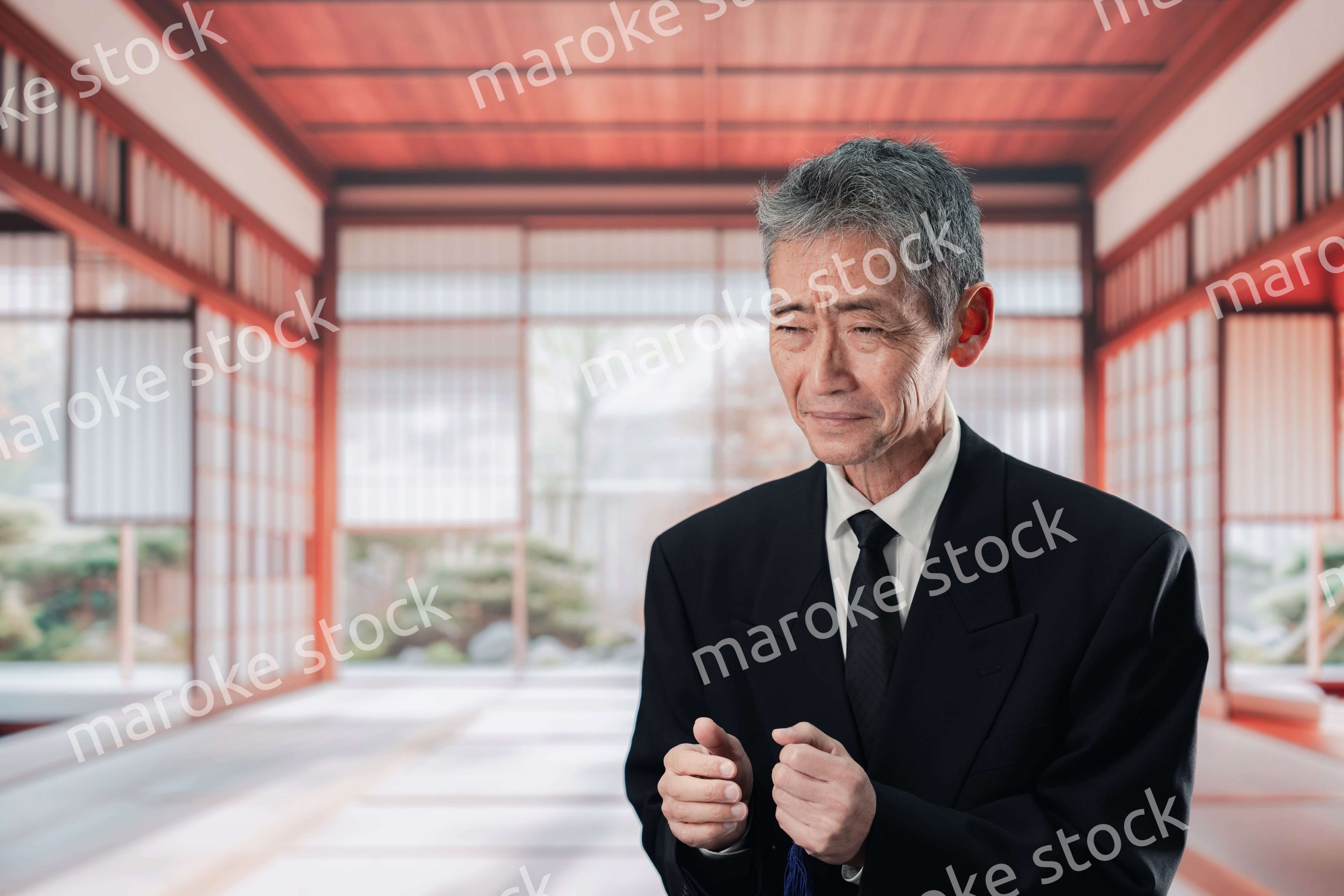 葬儀に参列する高齢の男性