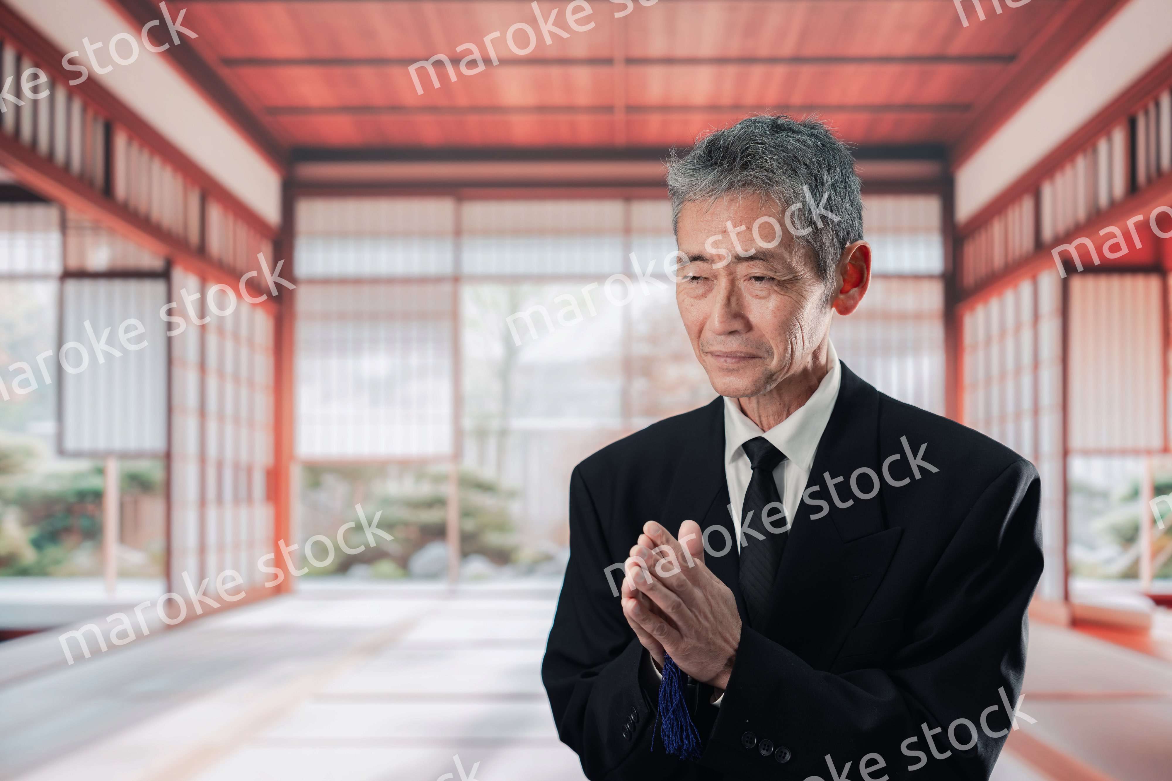 葬儀に参列する高齢の男性