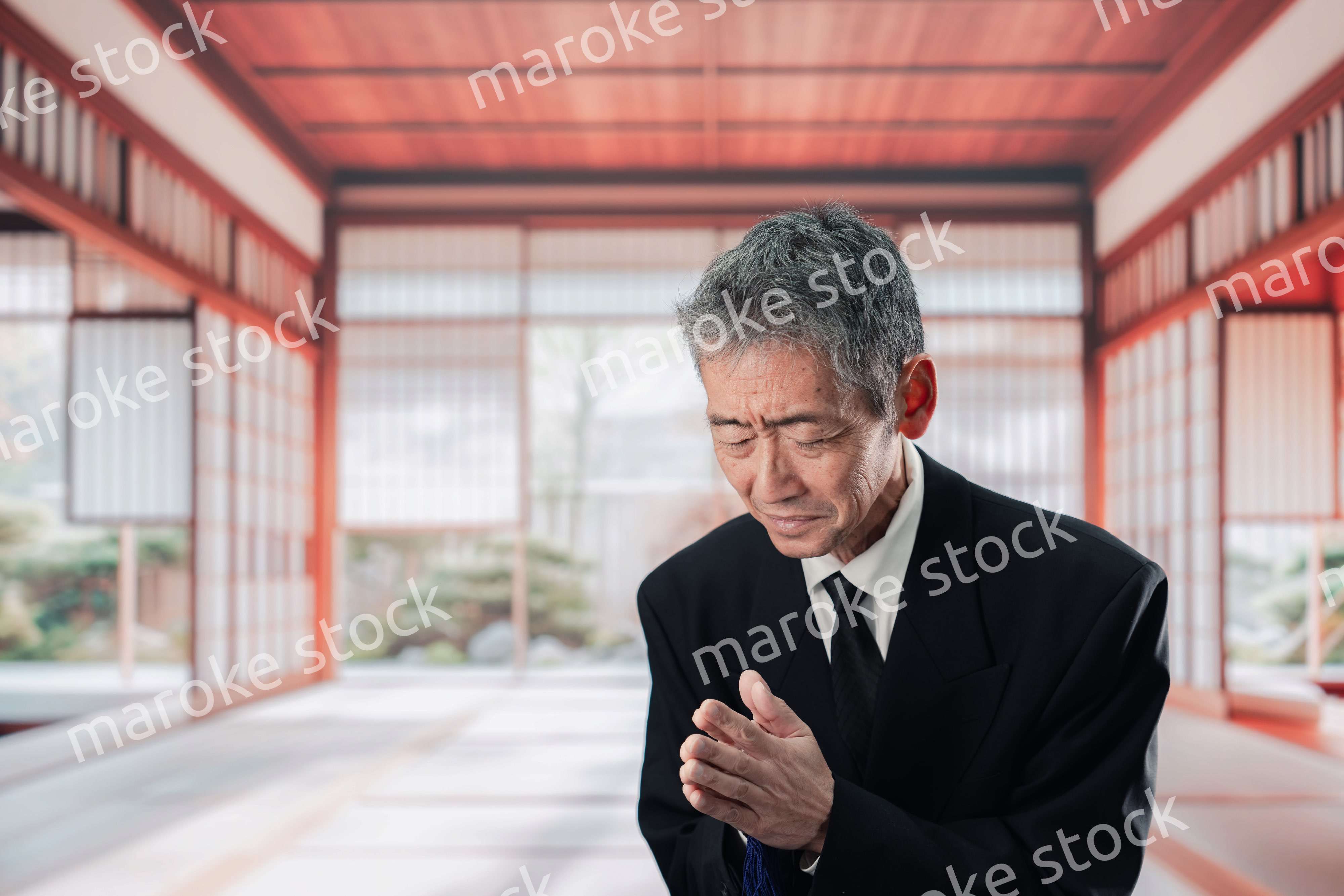 葬儀に参列する高齢の男性