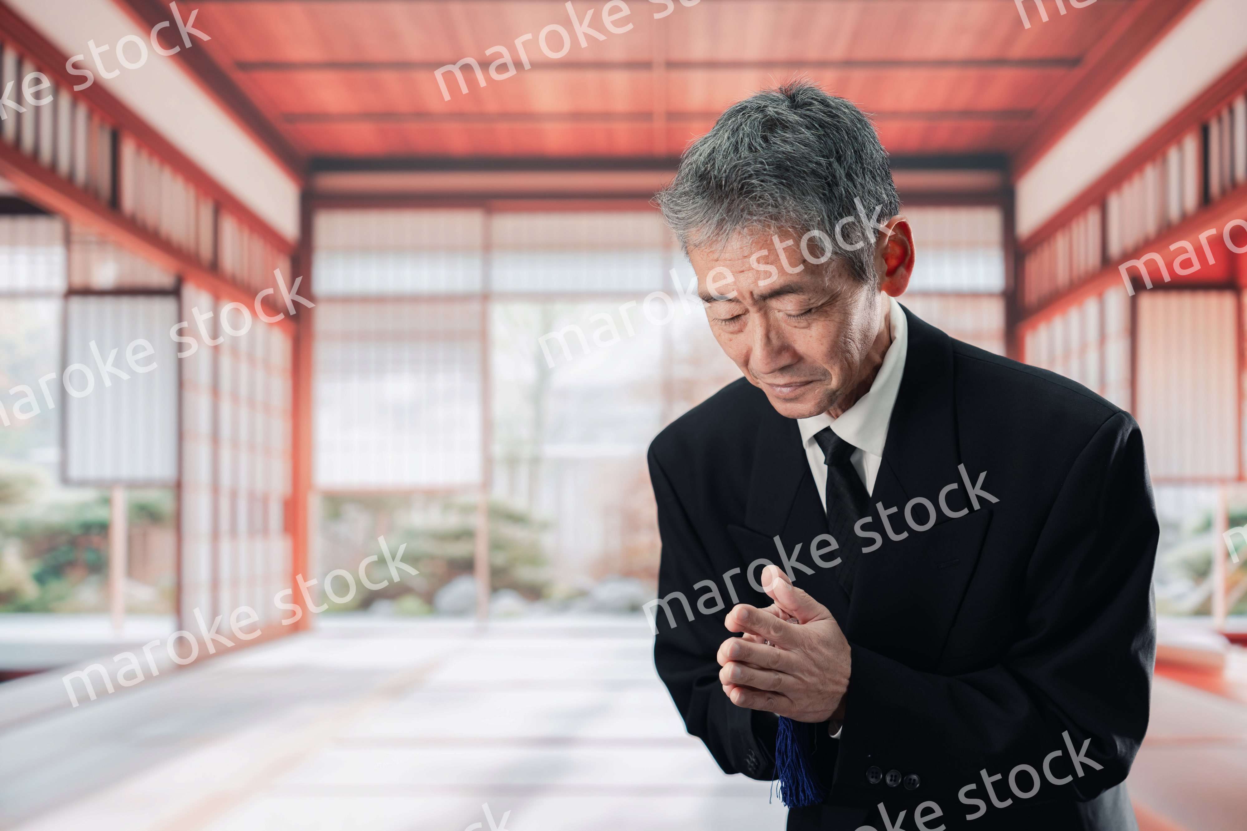 葬儀に参列する高齢の男性