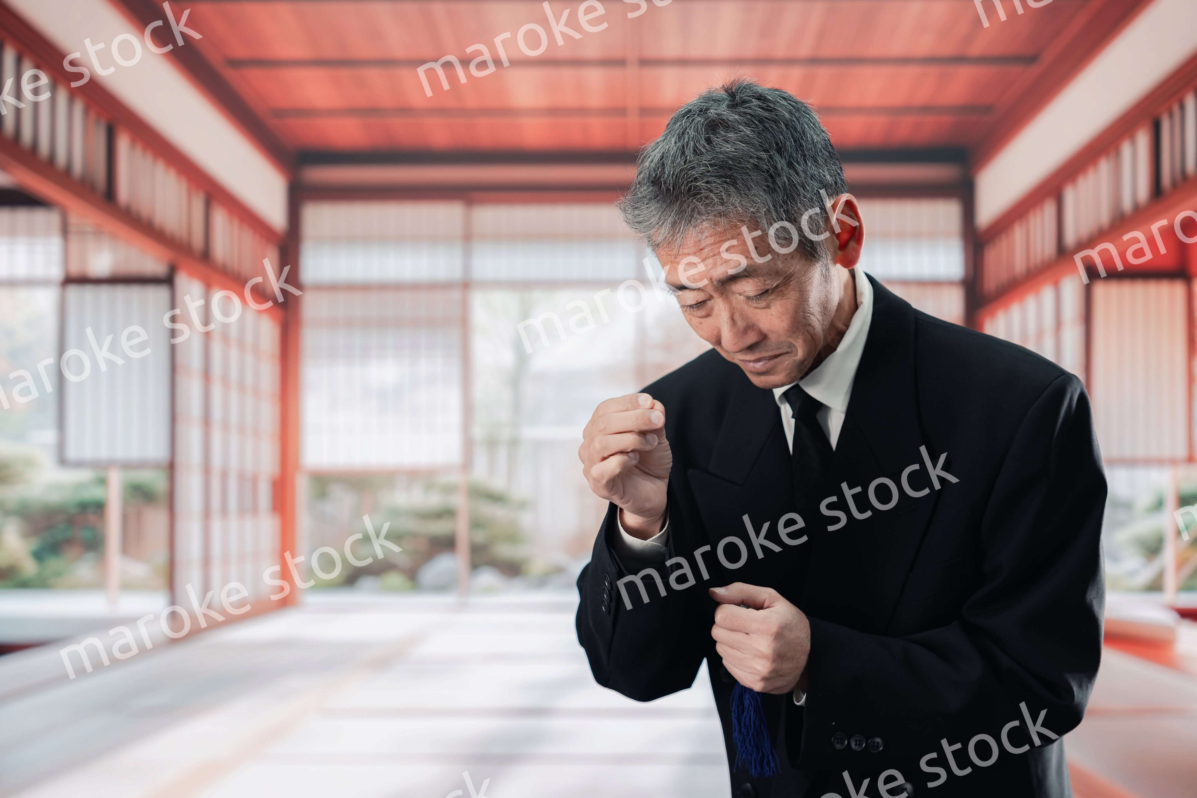 葬儀に参列する高齢の男性