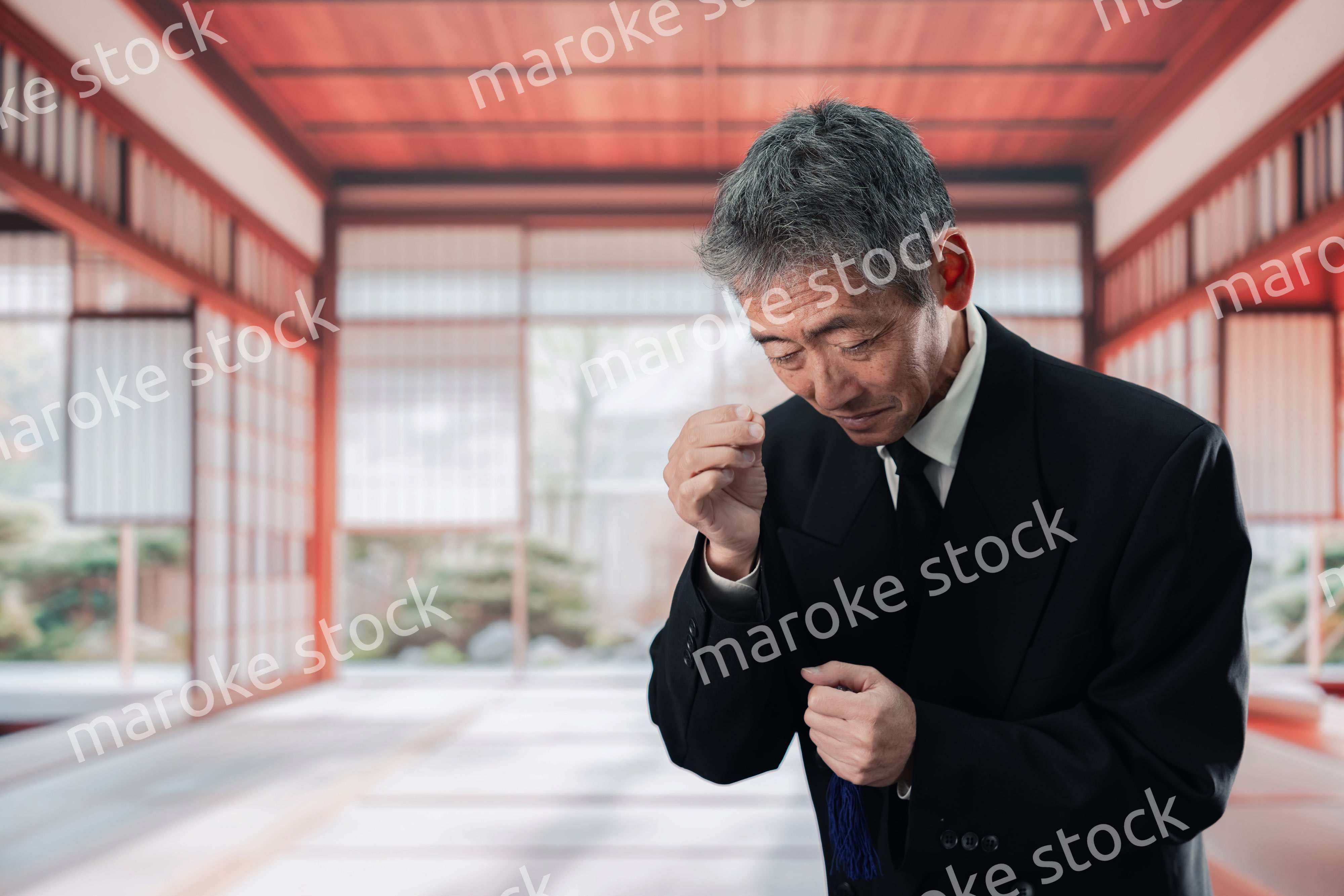 葬儀に参列する高齢の男性