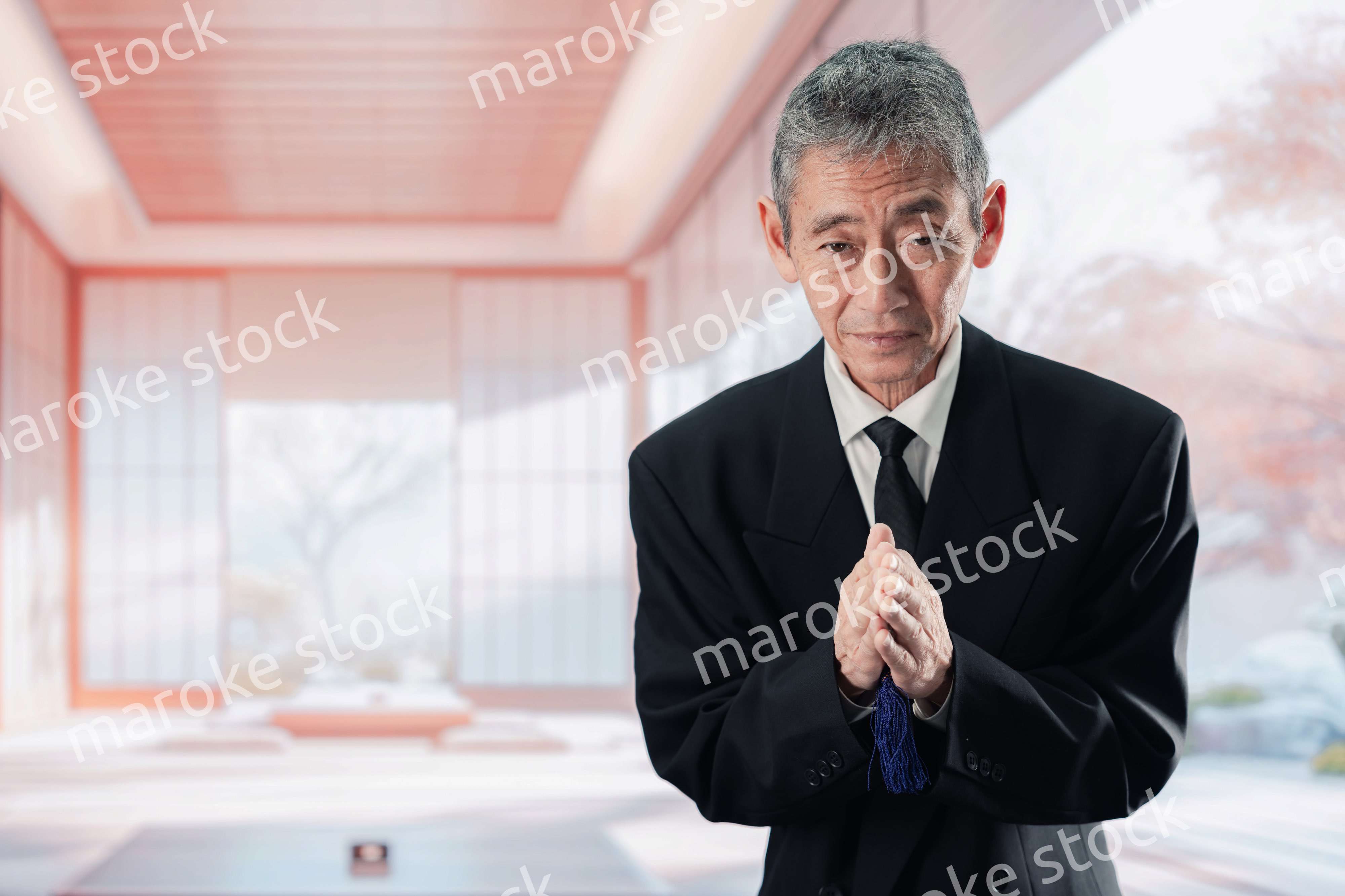 葬儀に参列する高齢の男性