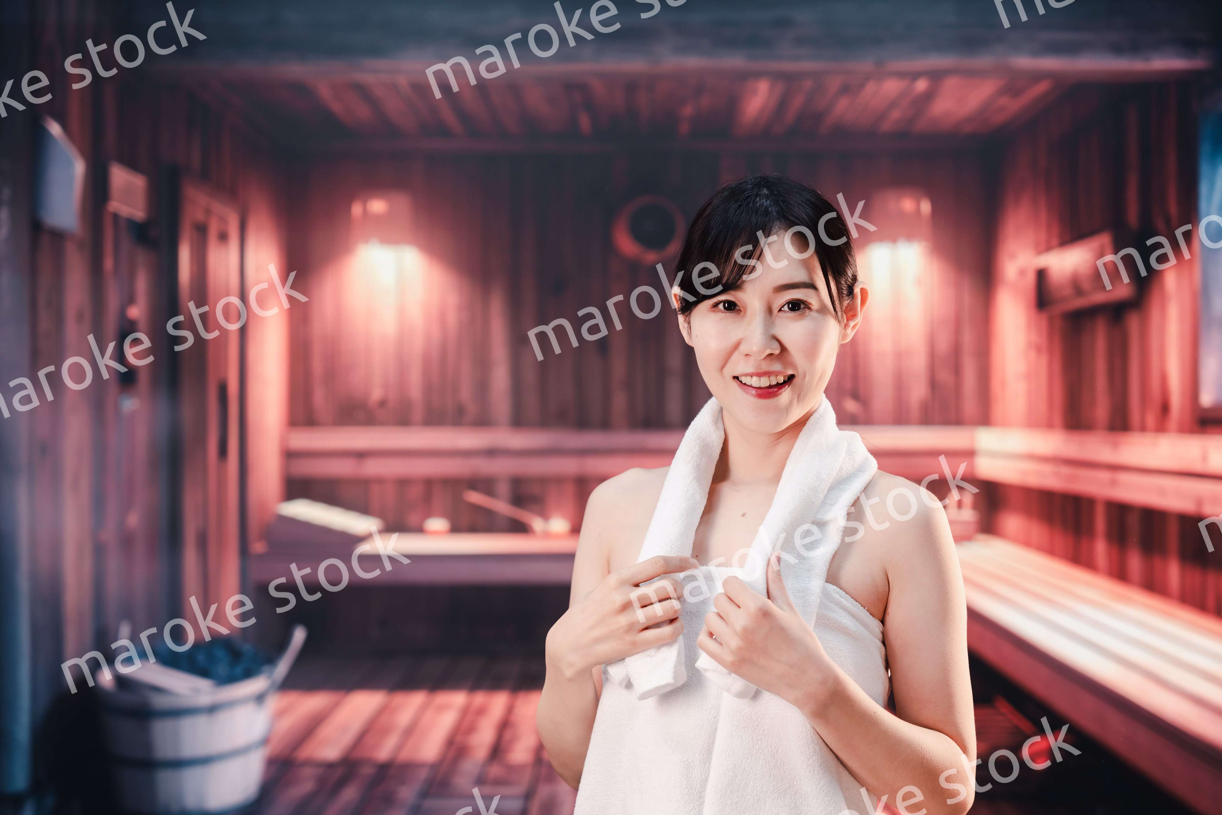 サウナで汗をかく若い女性