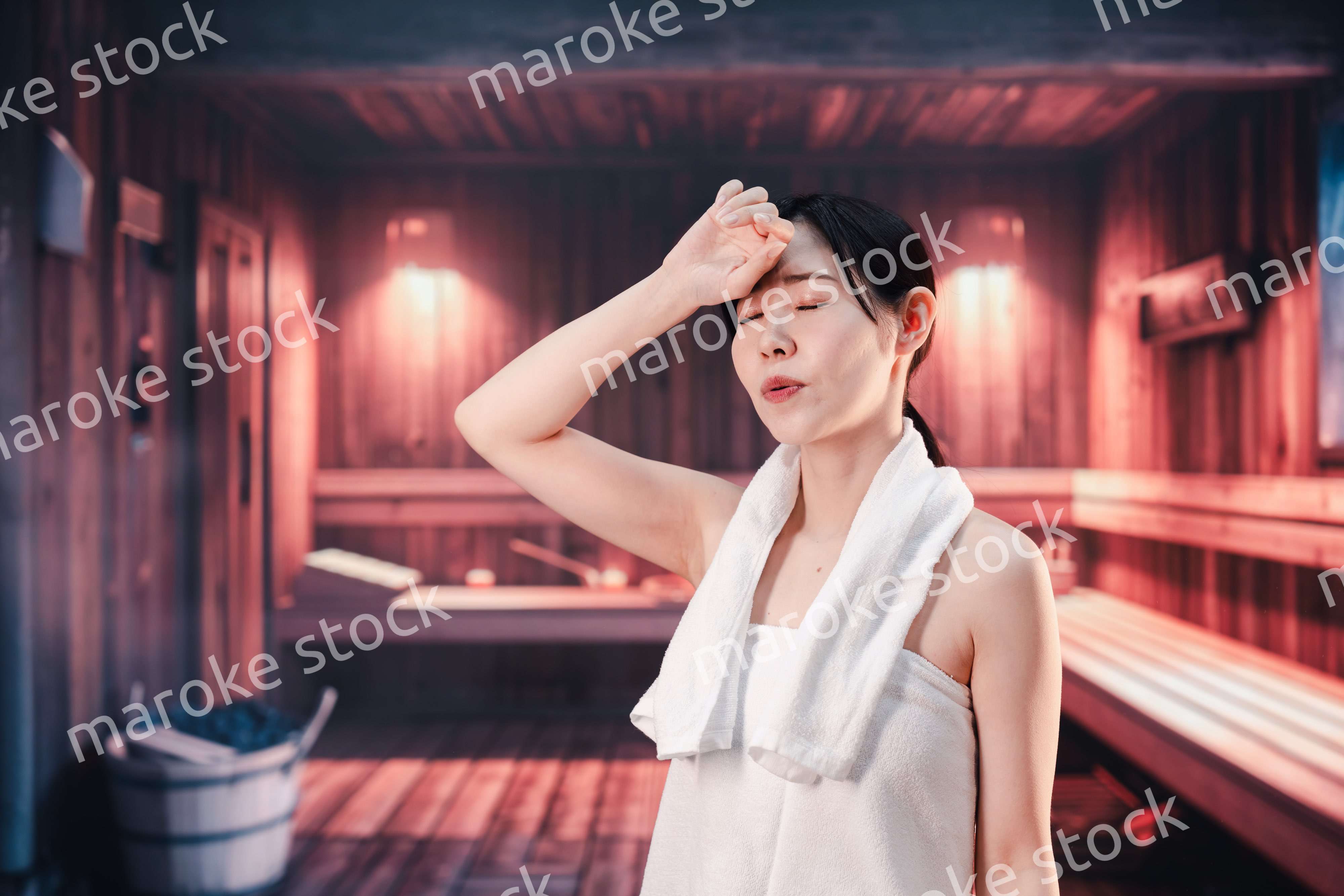 サウナで汗をかく若い女性