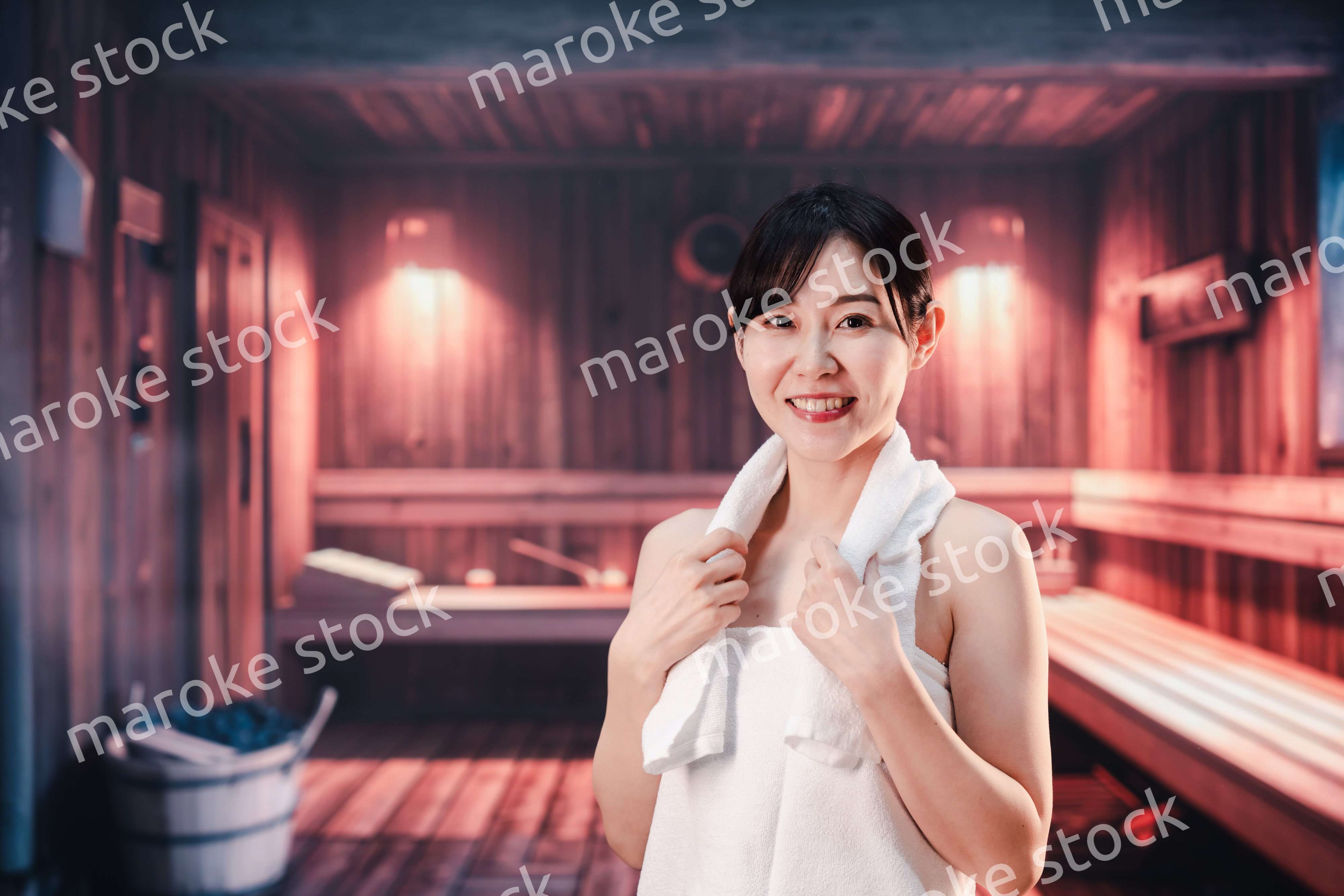 サウナで汗をかく若い女性