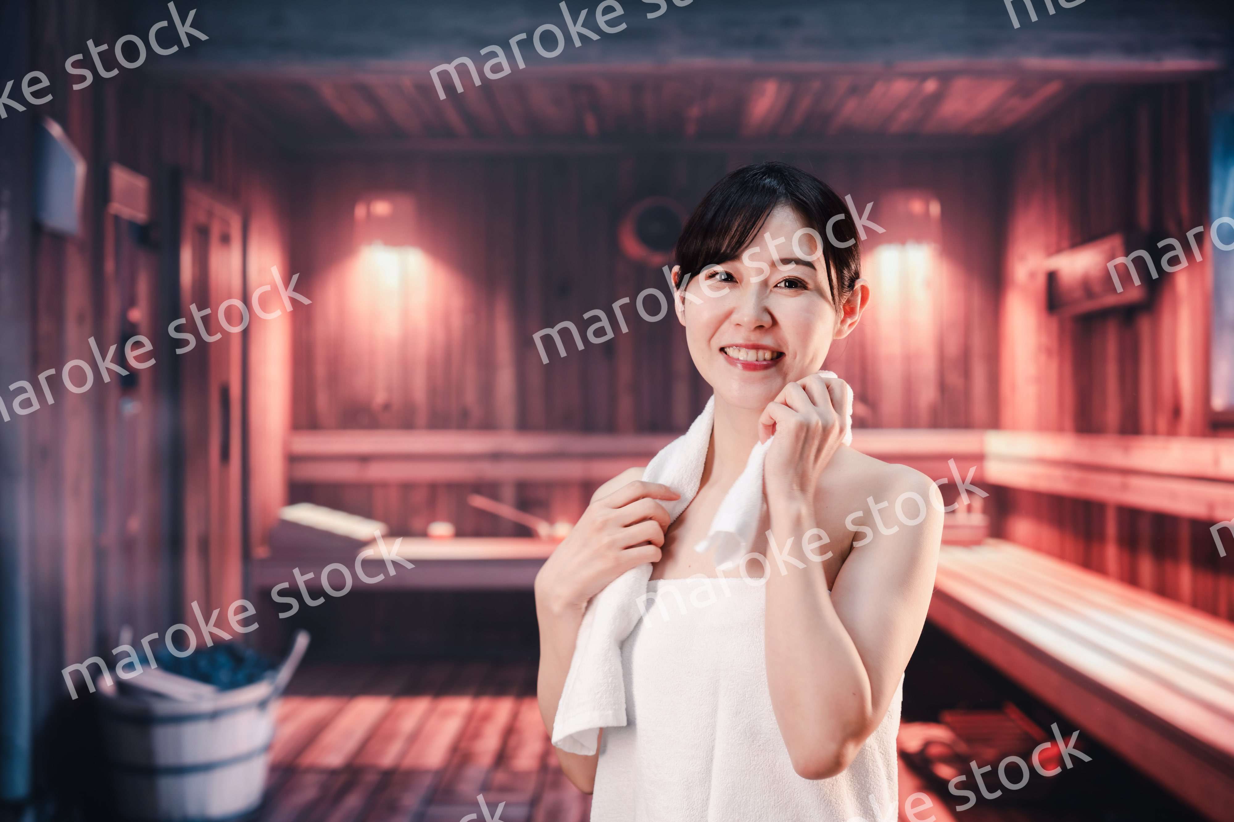 サウナで汗をかく若い女性