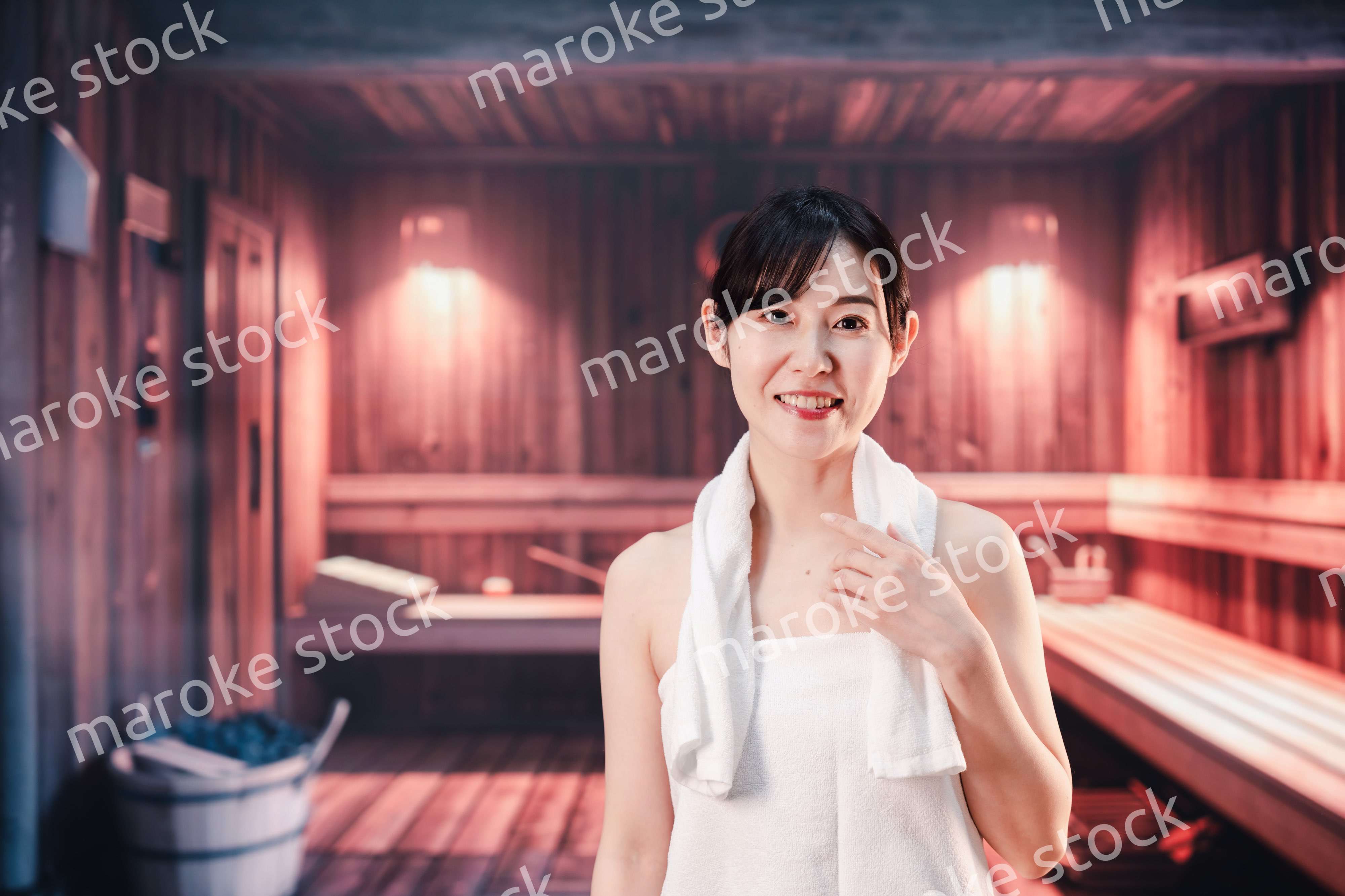 サウナで汗をかく若い女性