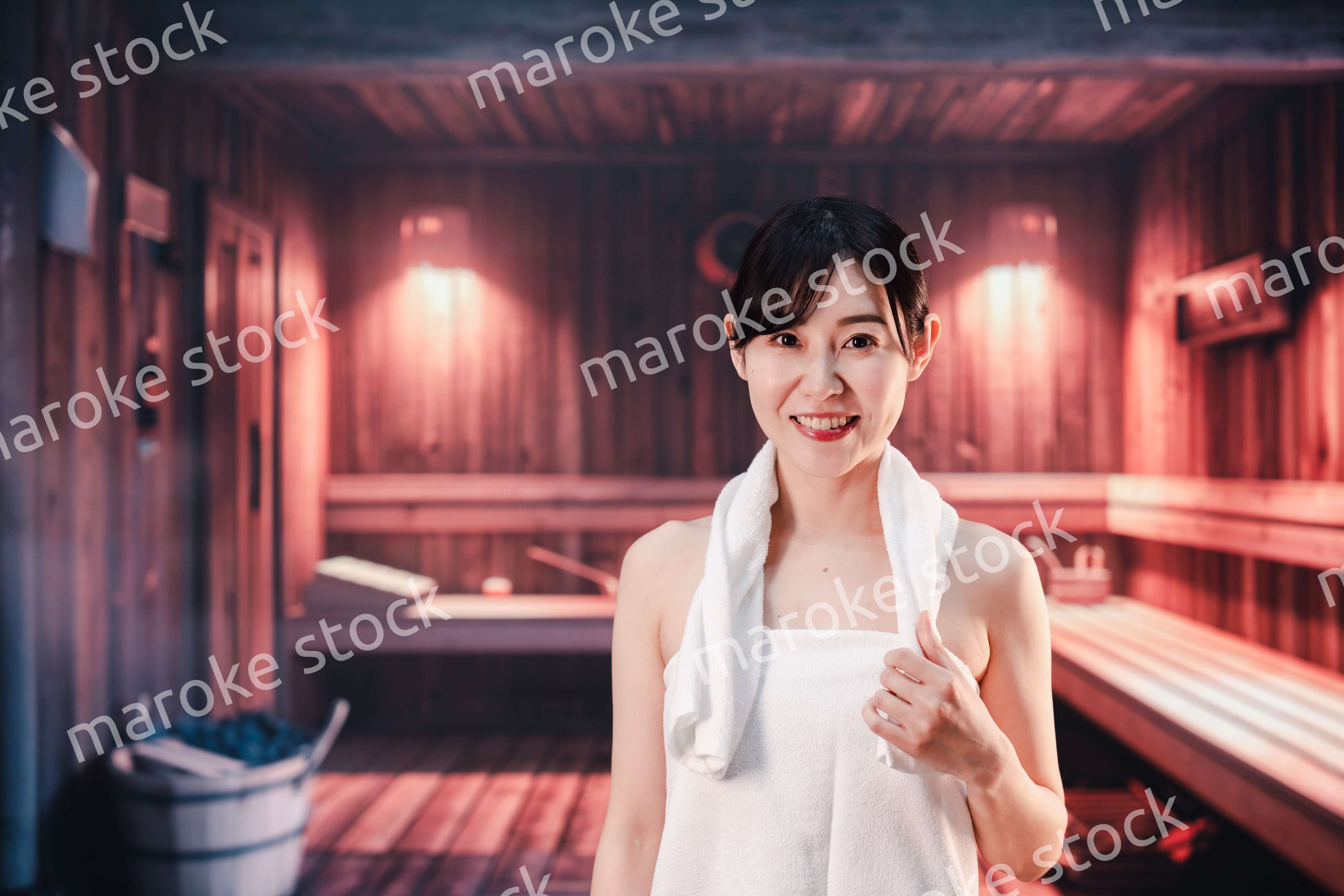 サウナで汗をかく若い女性