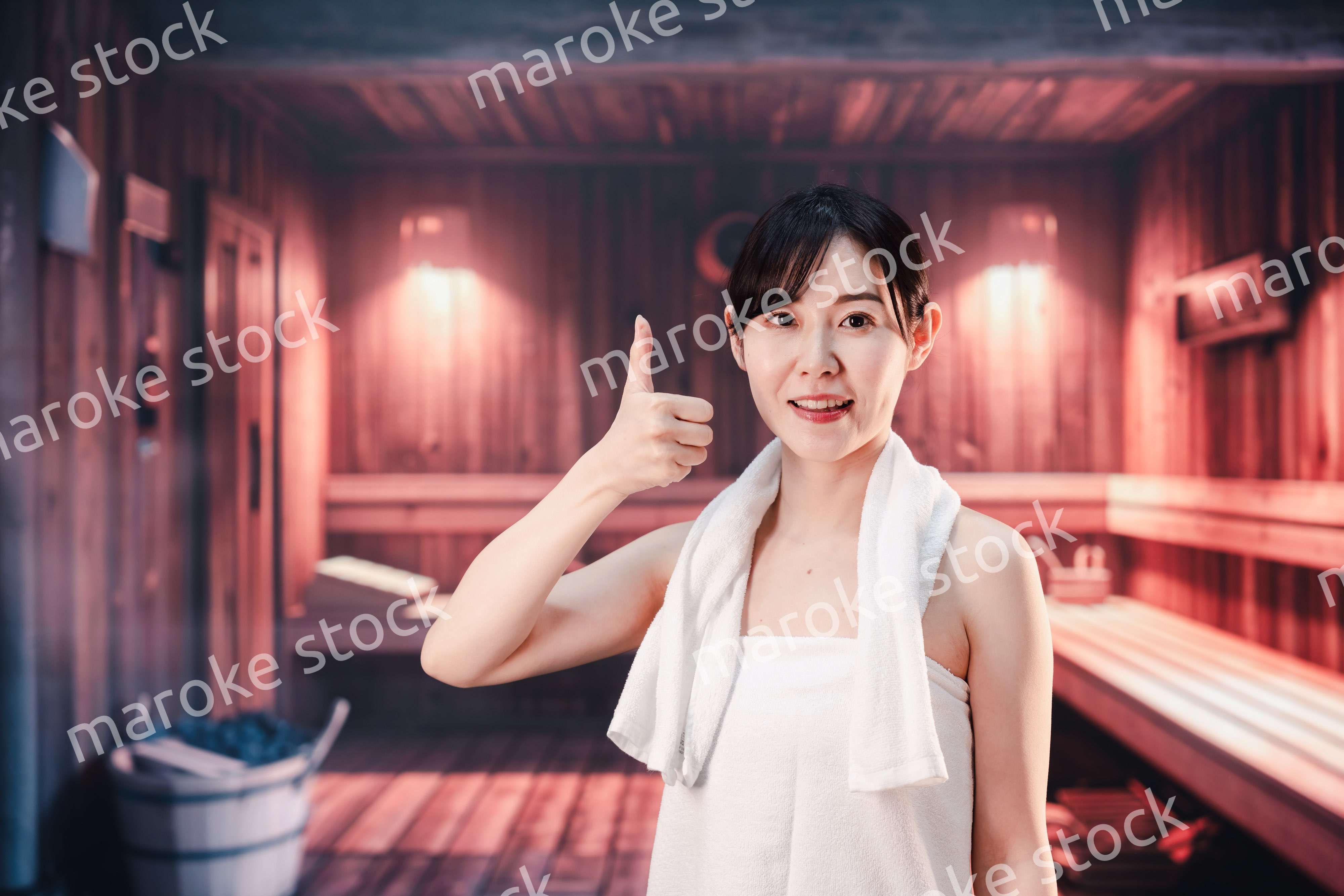 サウナで汗をかく若い女性