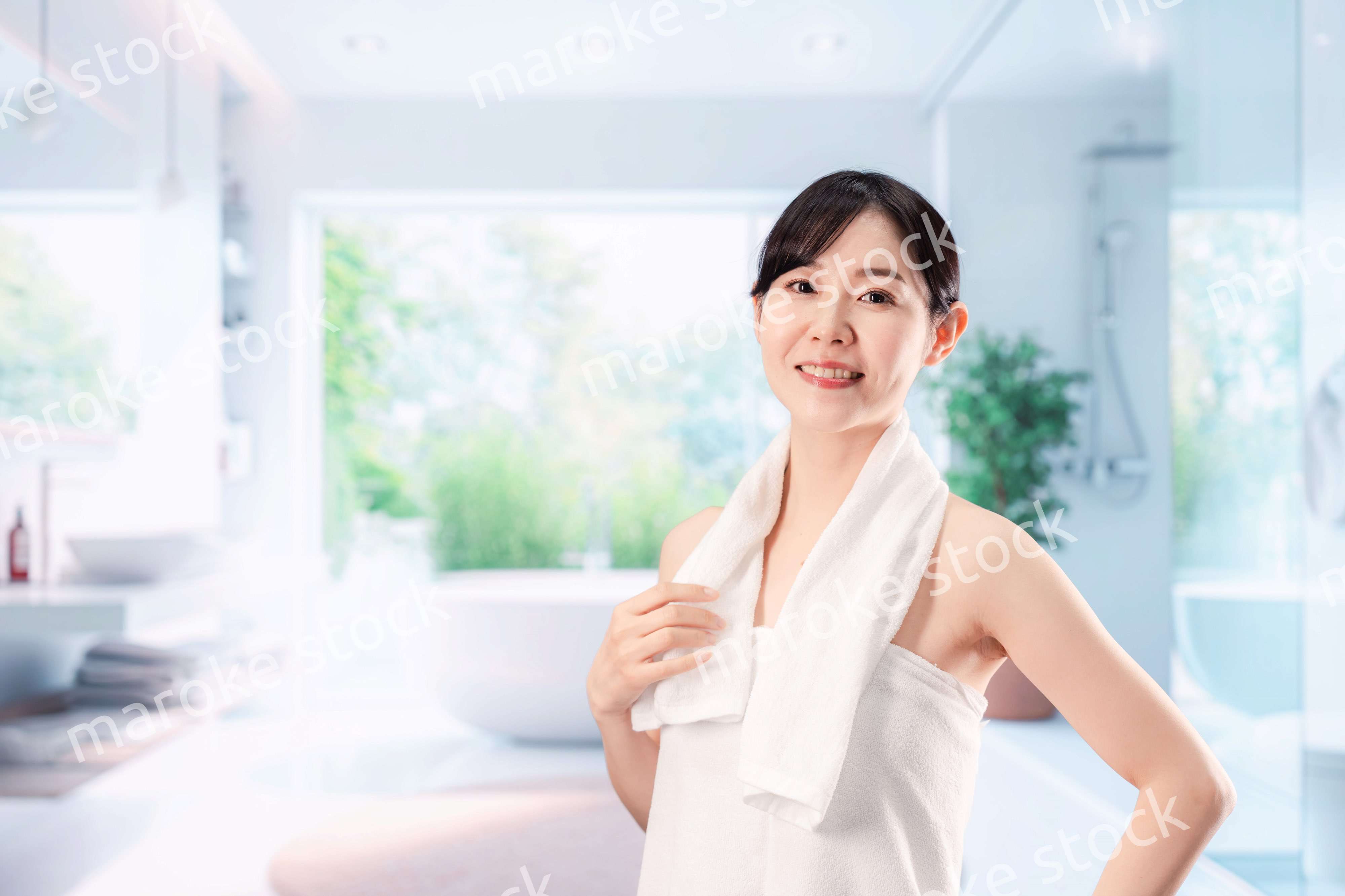 バスルームでボディケアをする若い女性