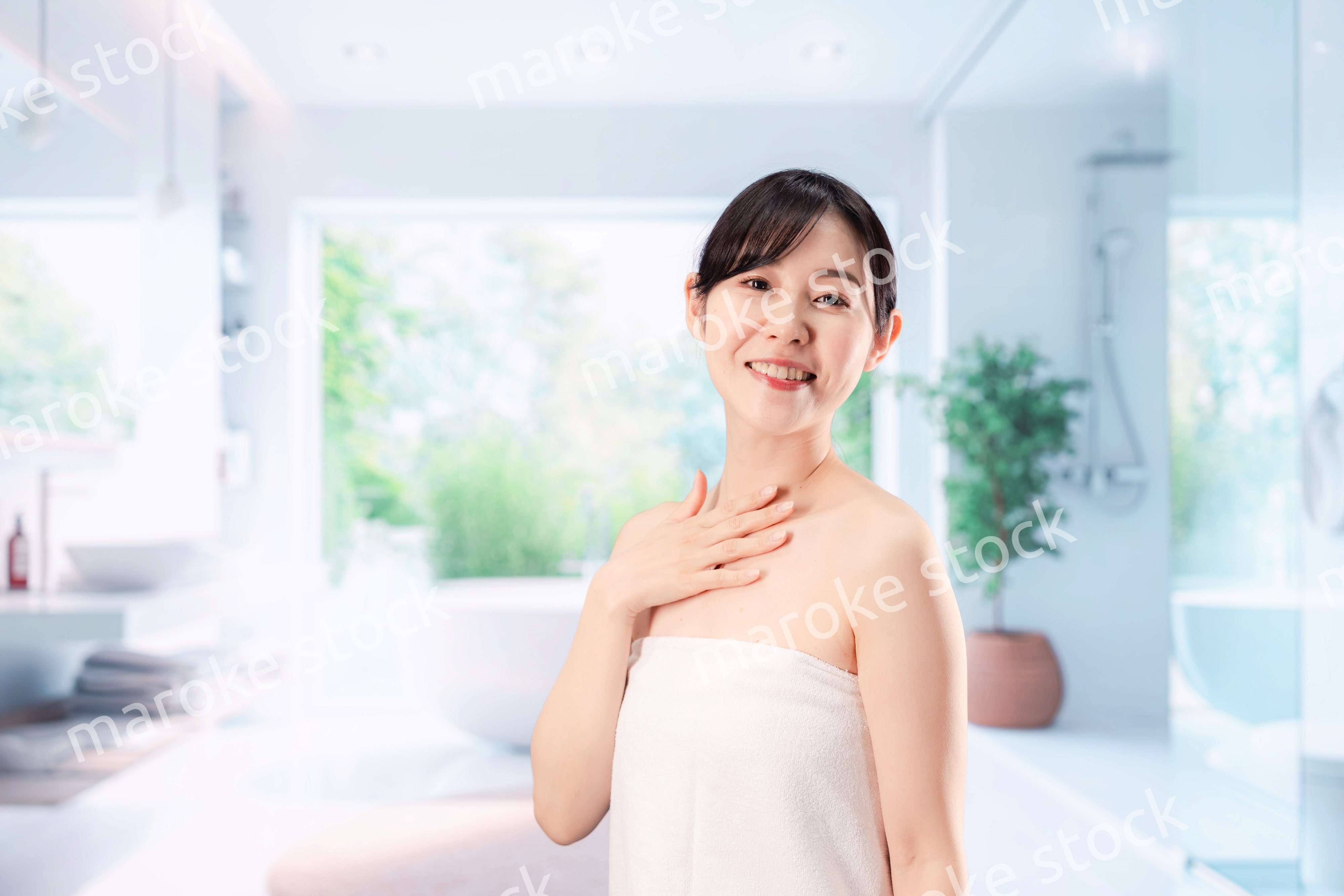 バスルームでボディケアをする若い女性