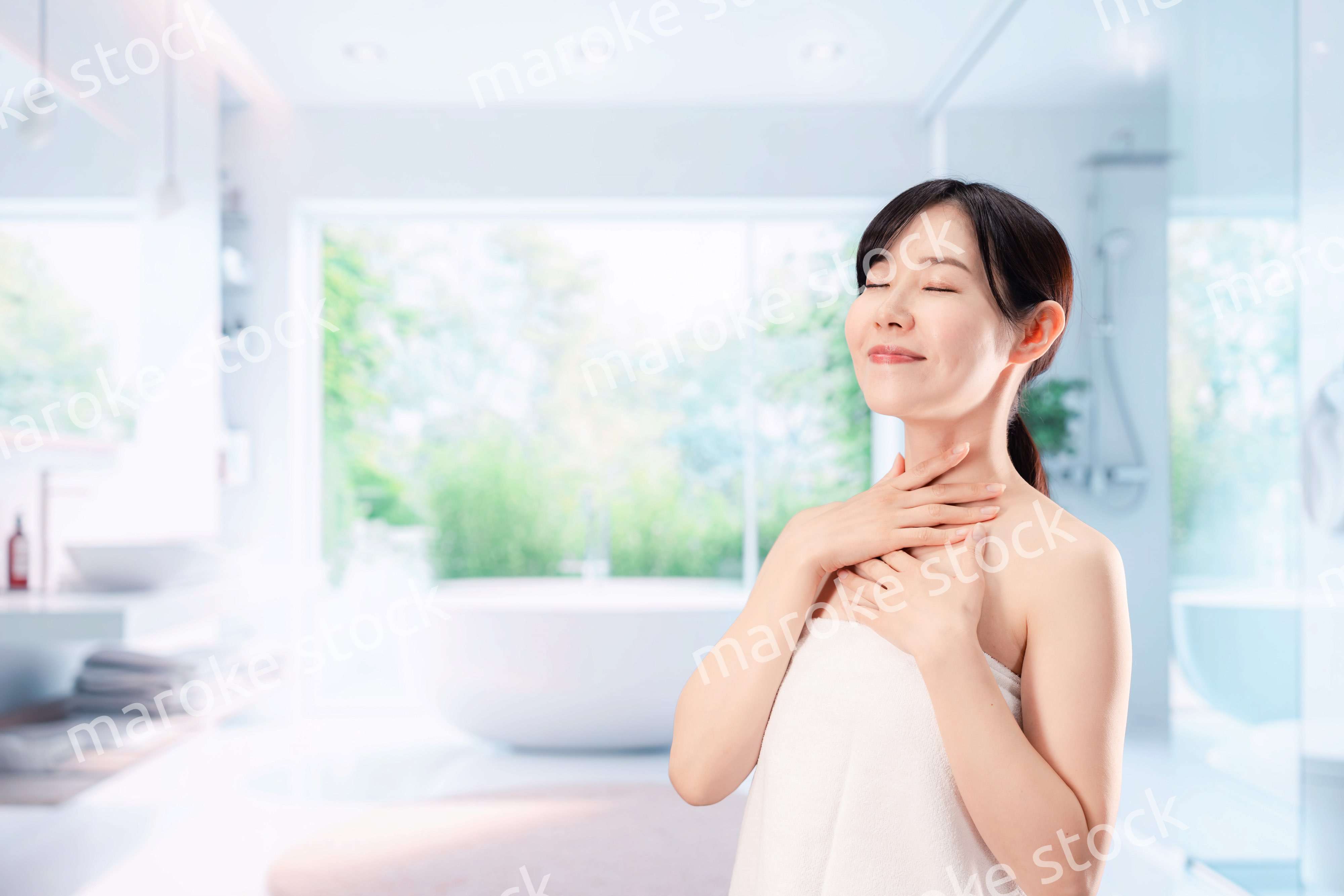 バスルームでボディケアをする若い女性