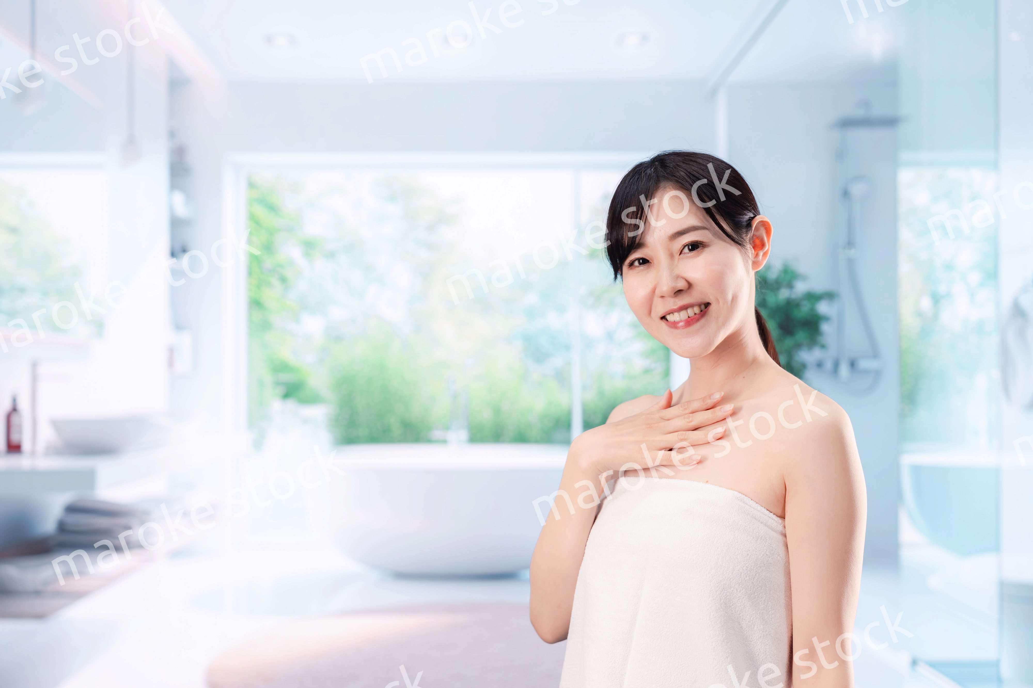 バスルームでボディケアをする若い女性