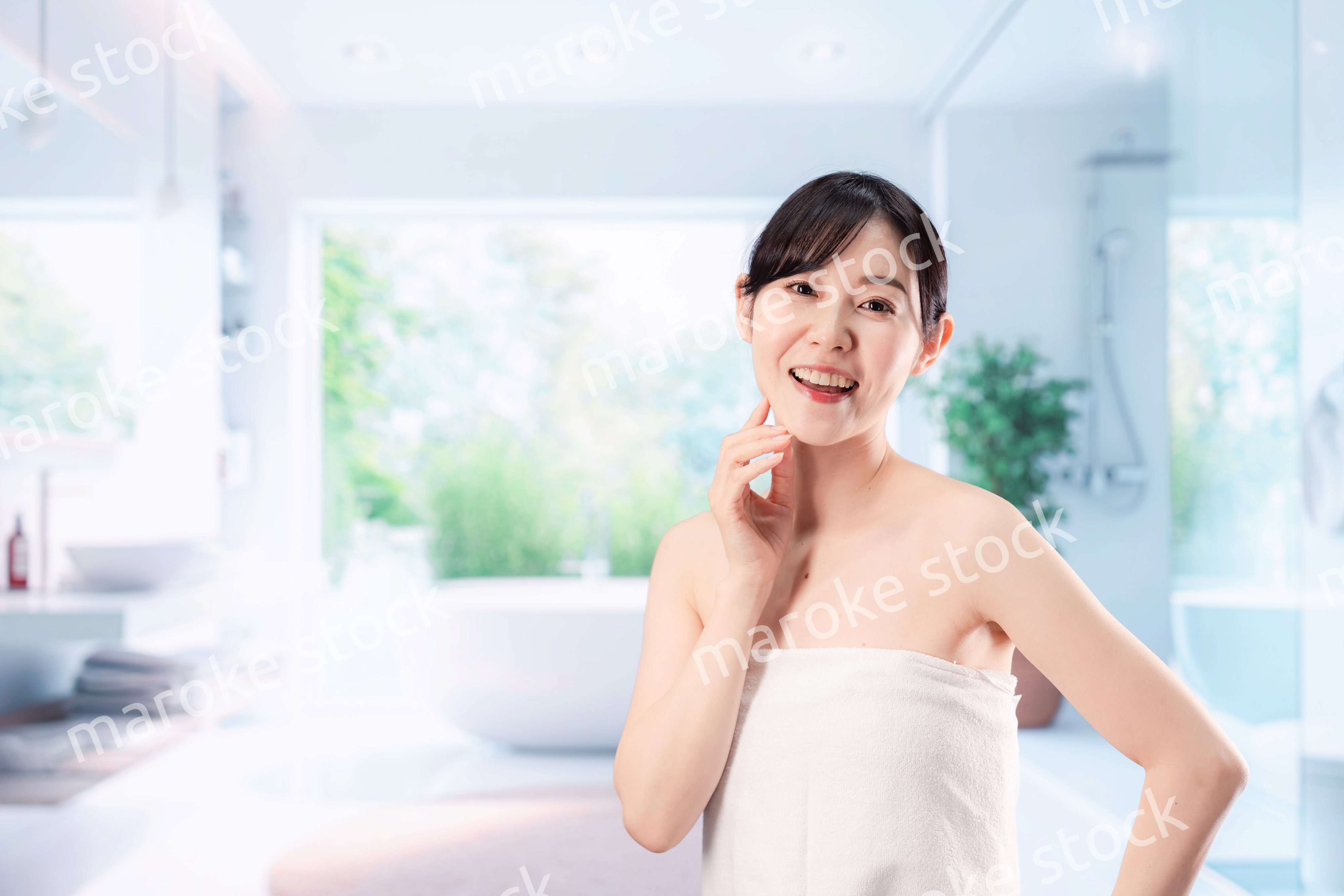 バスルームでボディケアをする若い女性