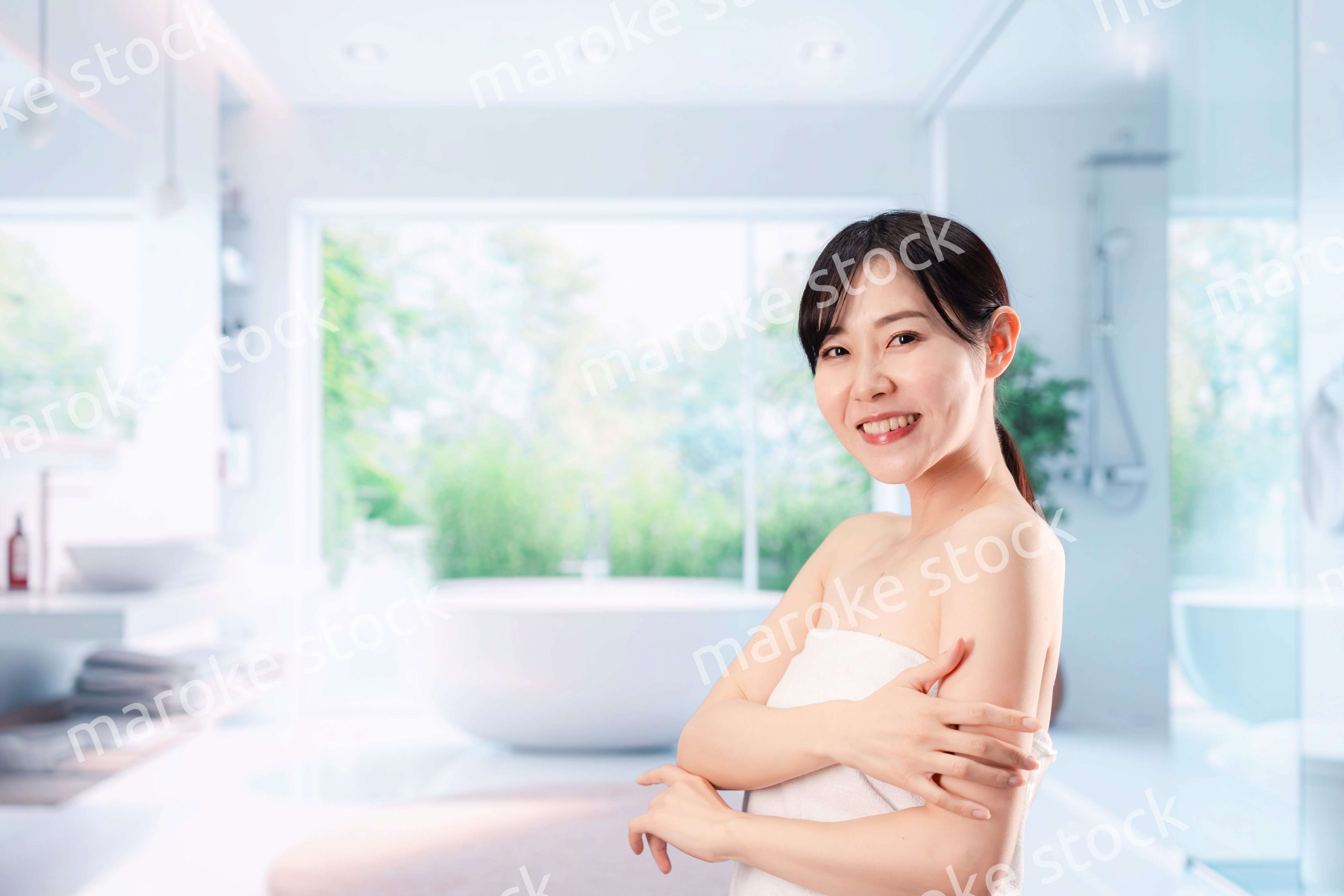 バスルームでボディケアをする若い女性