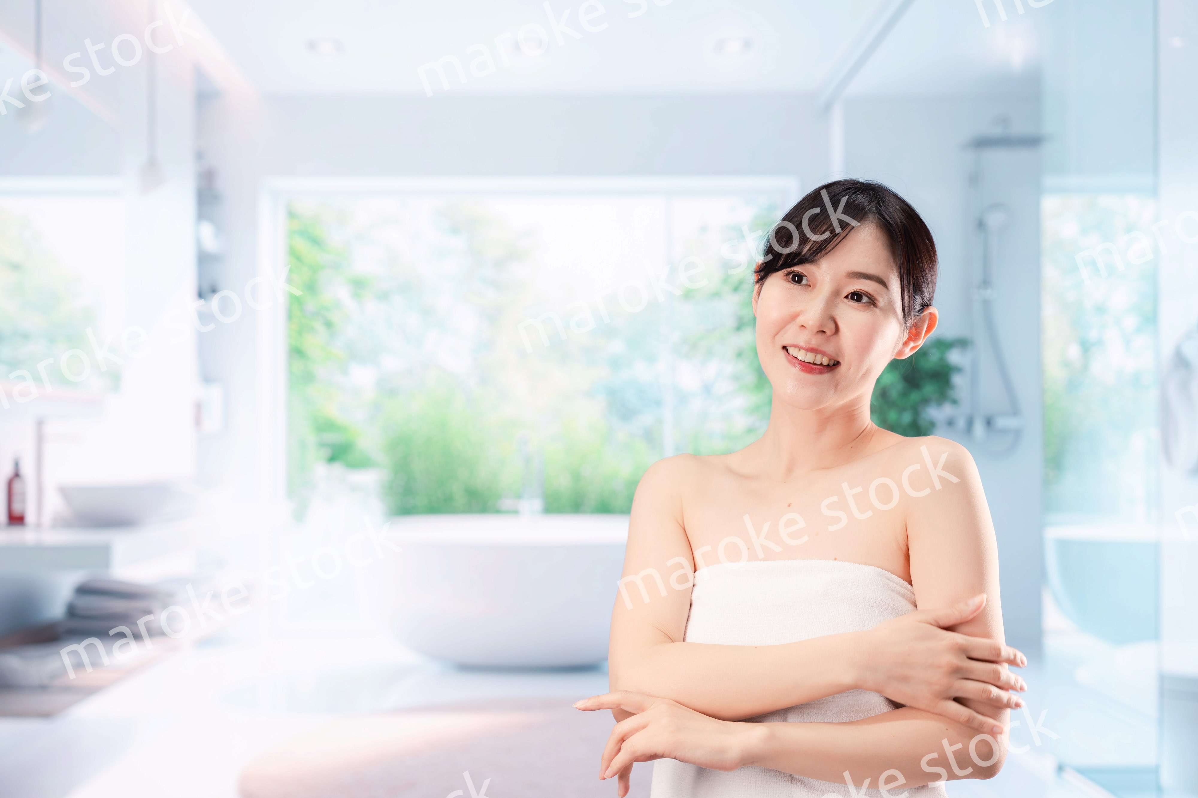 バスルームでボディケアをする若い女性