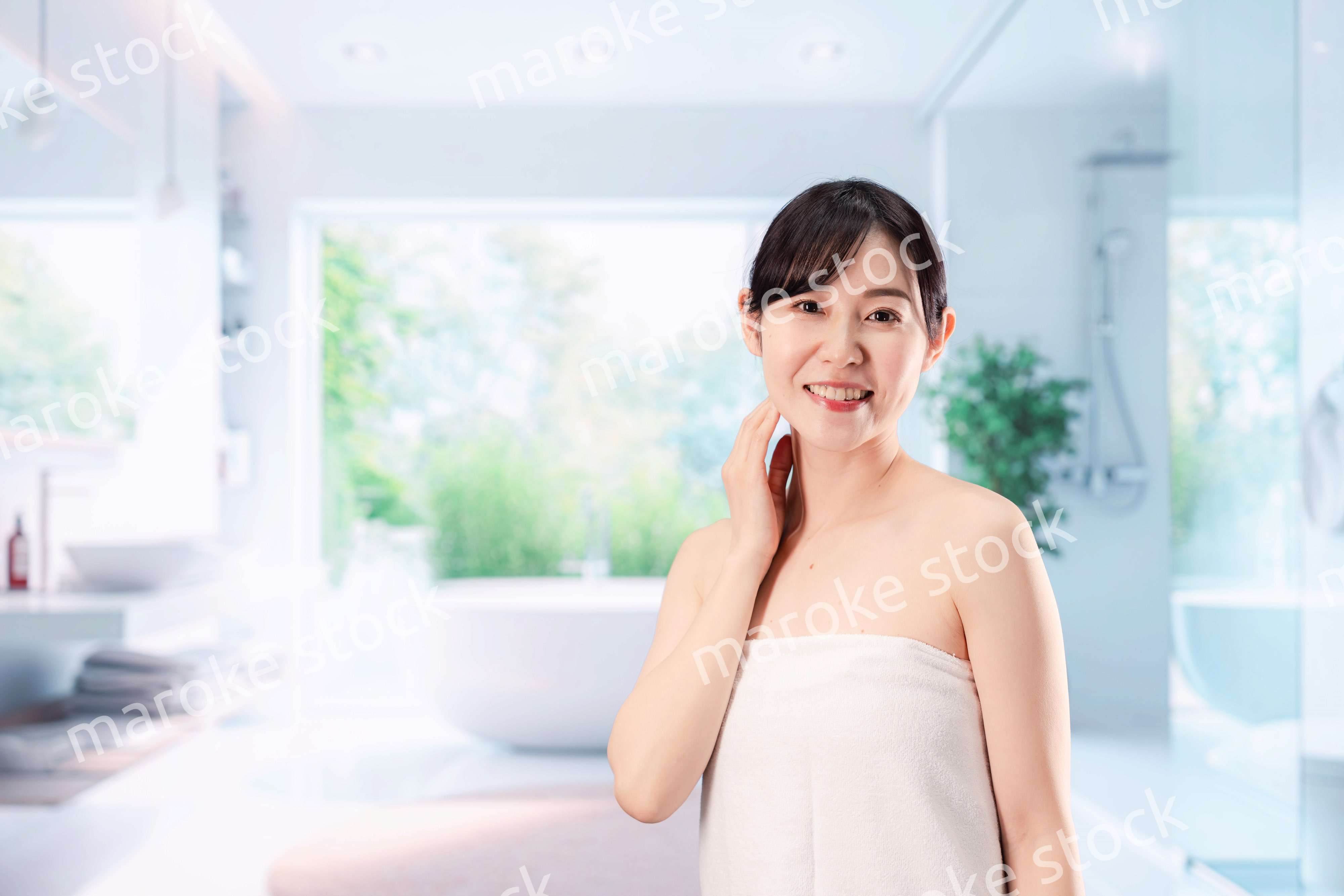 バスルームでボディケアをする若い女性