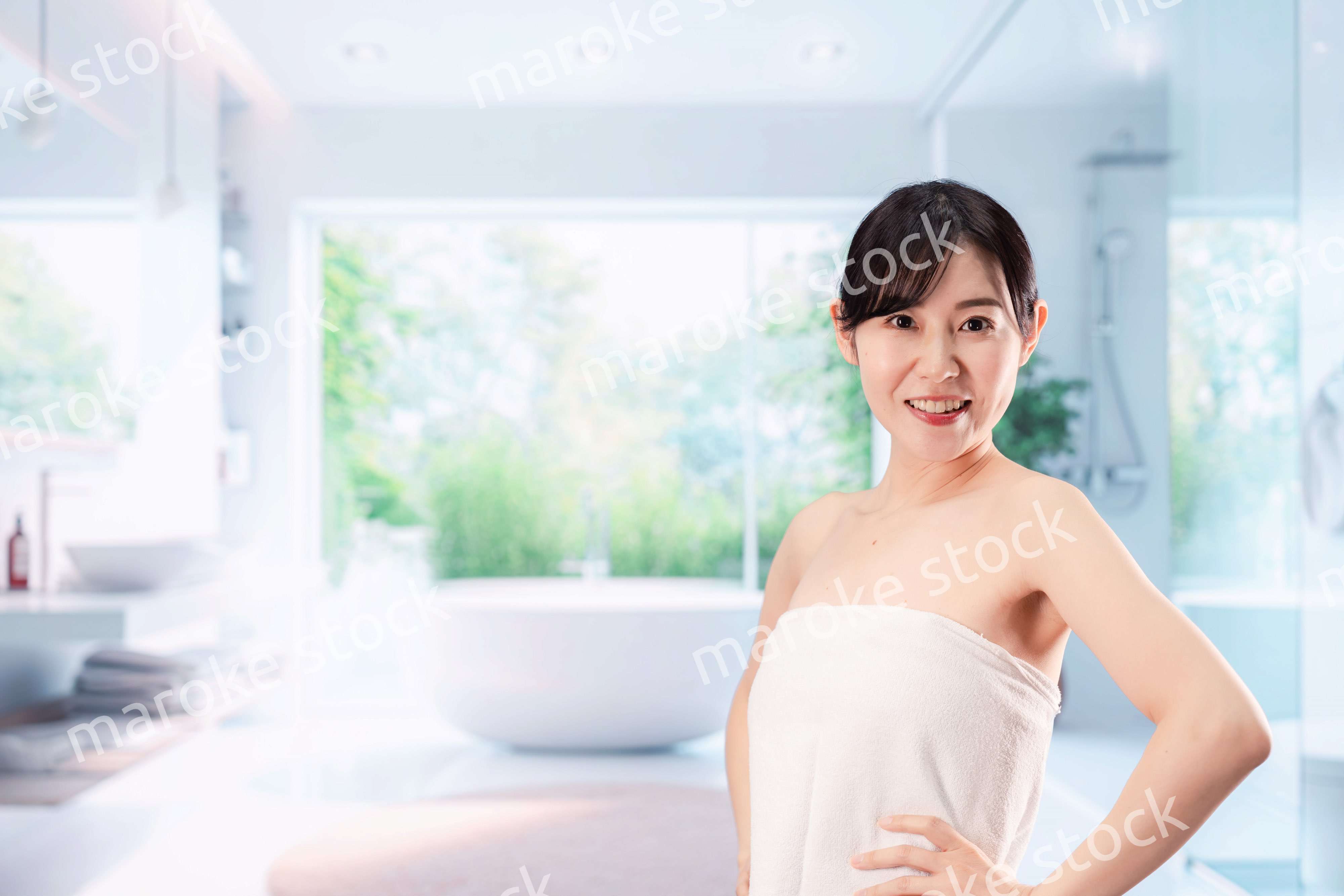 バスルームでボディケアをする若い女性