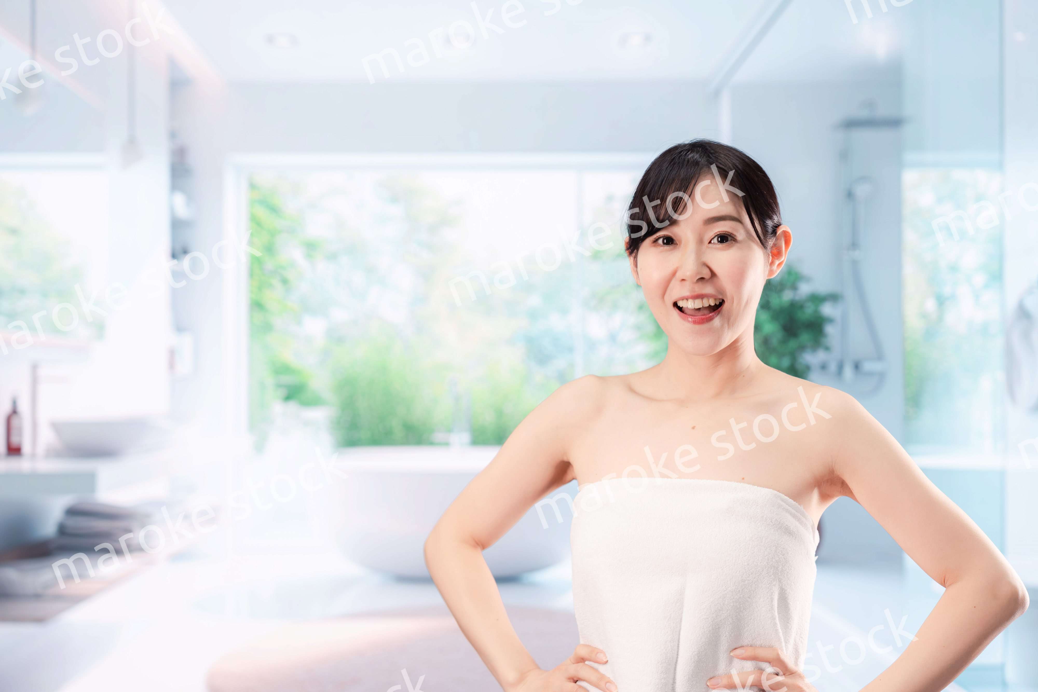 バスルームでボディケアをする若い女性