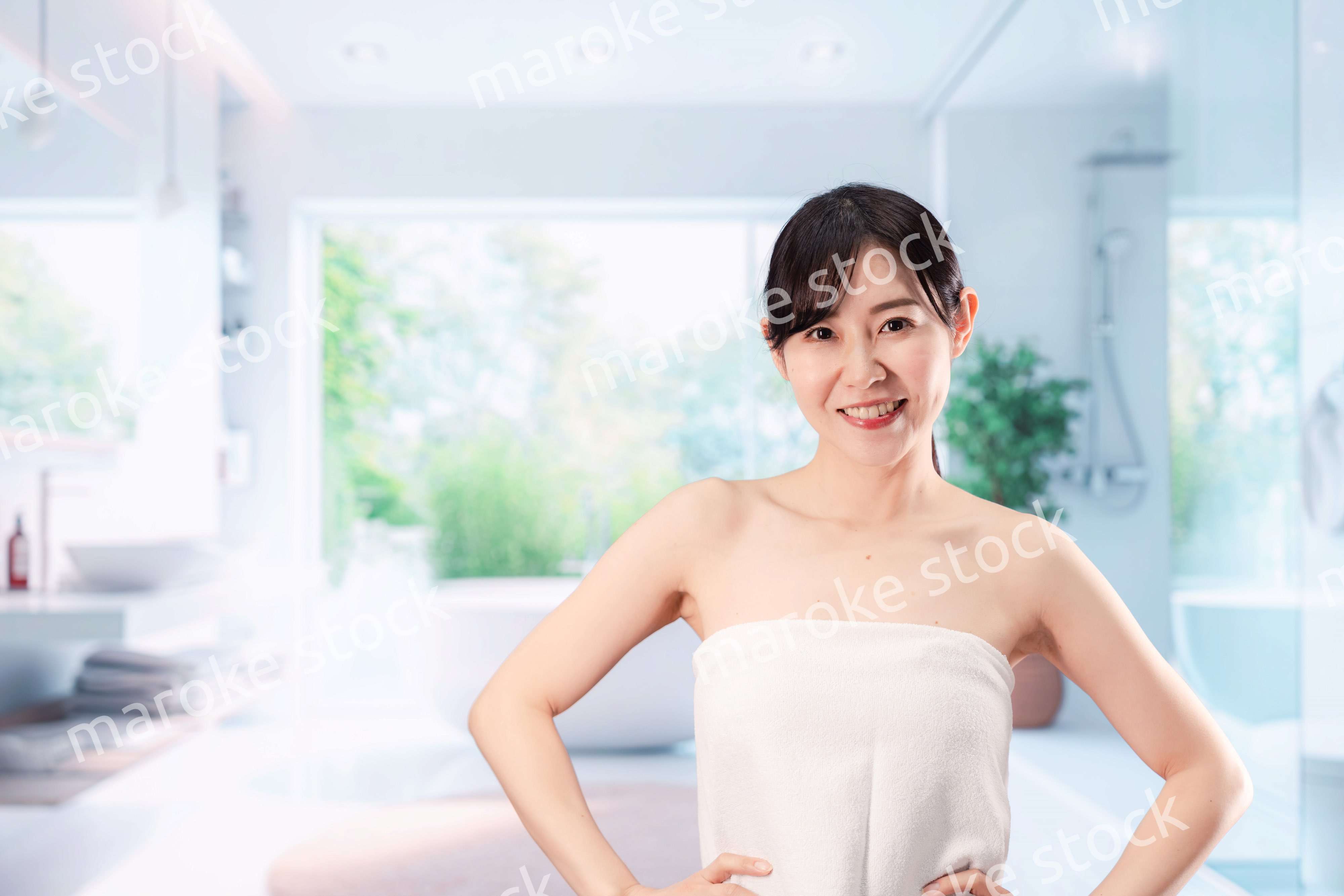 バスルームでボディケアをする若い女性