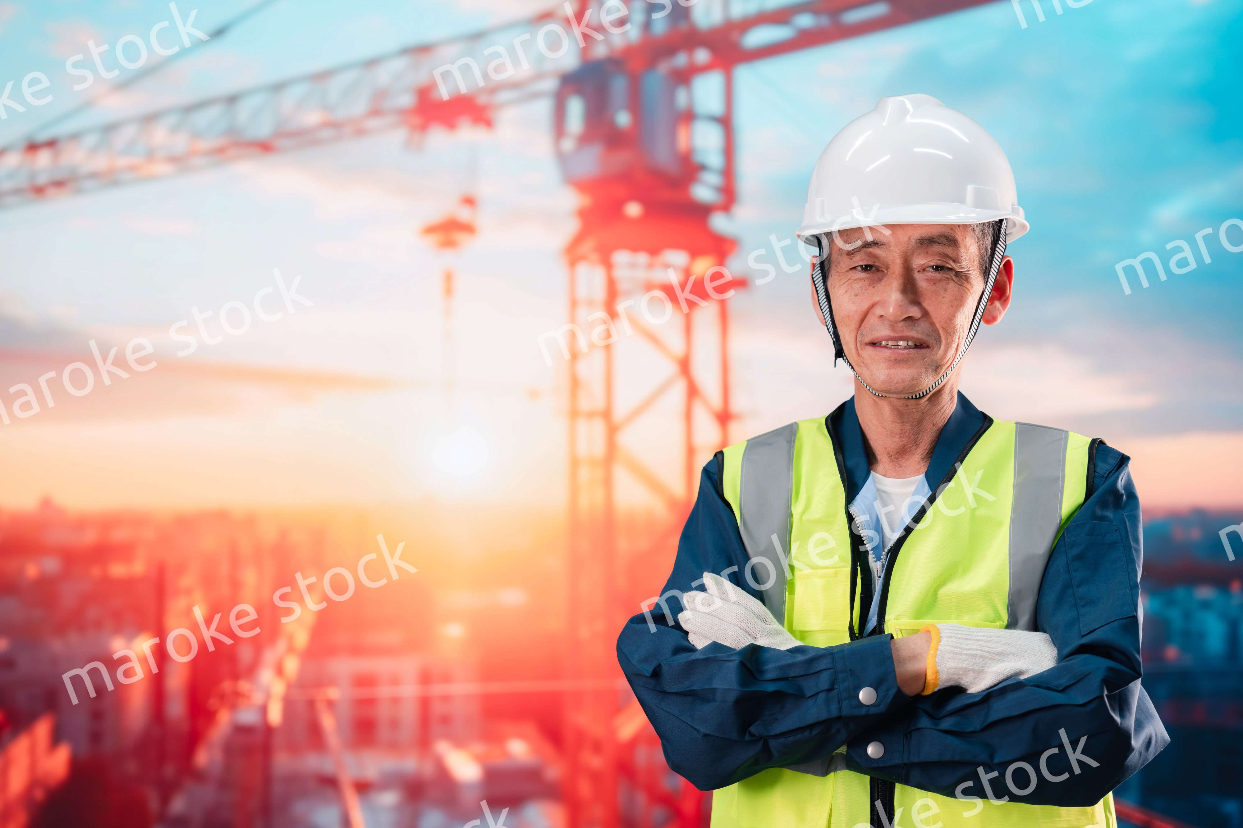 高層ビルの建設現場で監督をする高齢の男性