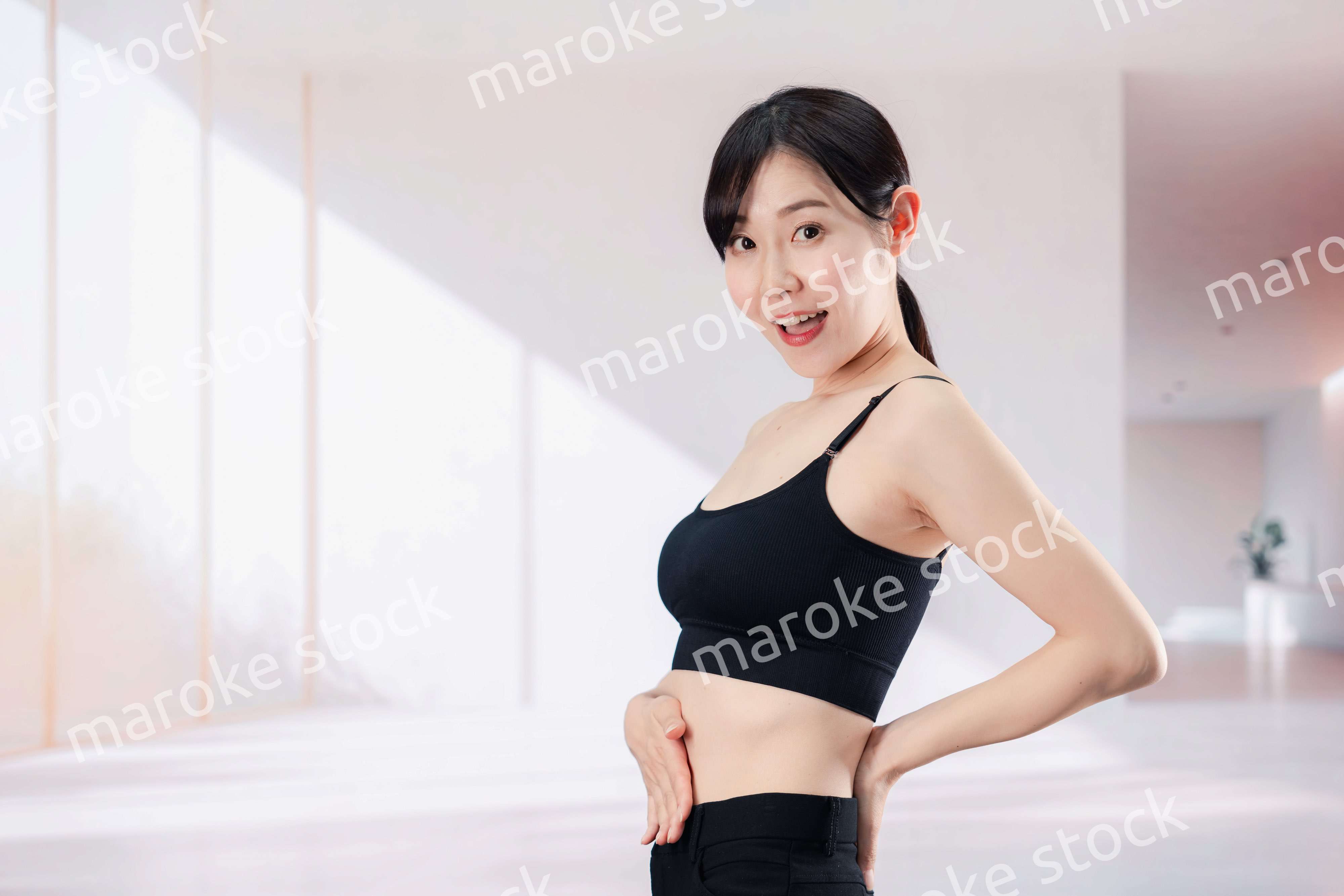 ダイエットの効果を実感して喜ぶ若い女性