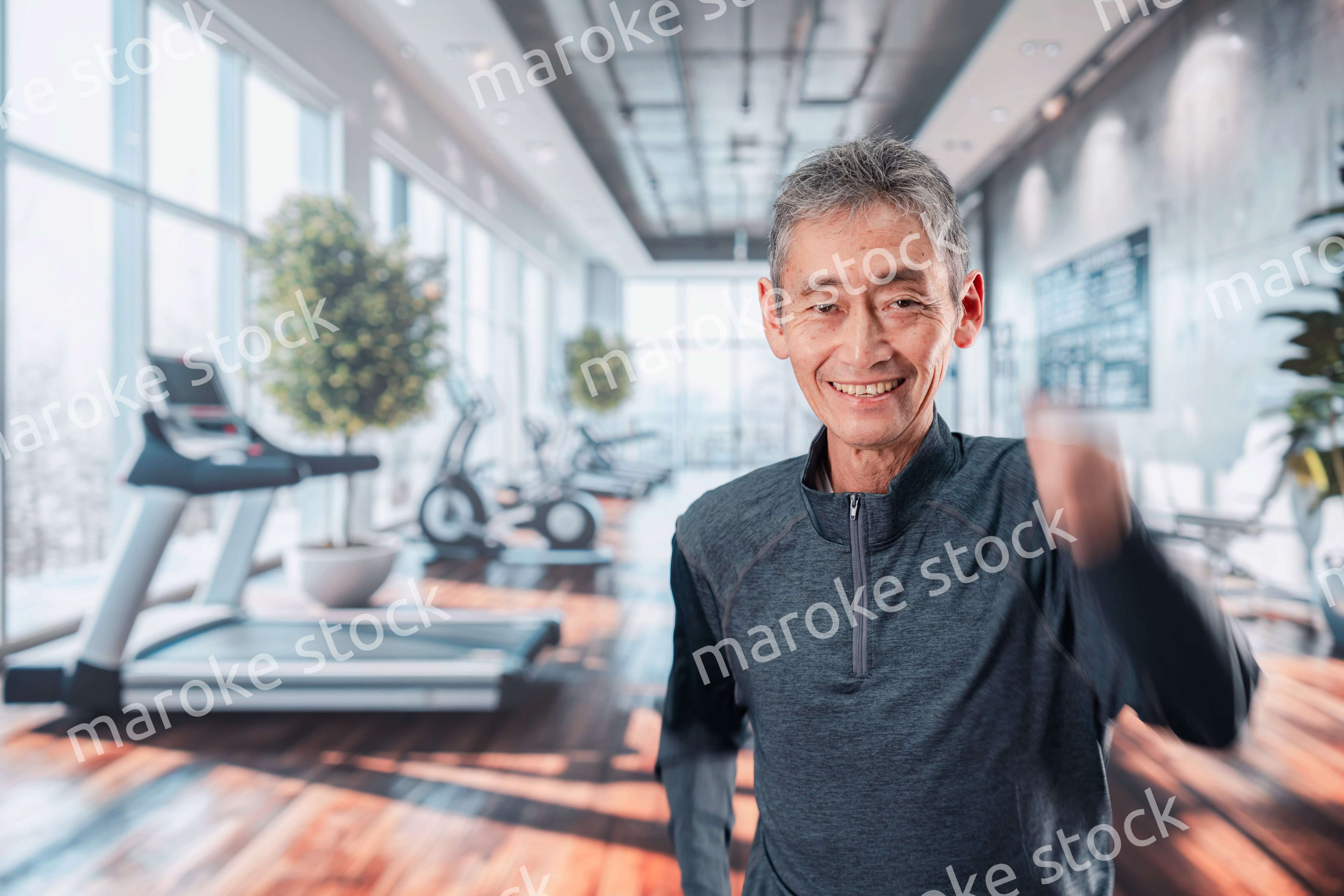 スポーツジムで運動をするシニアの男性