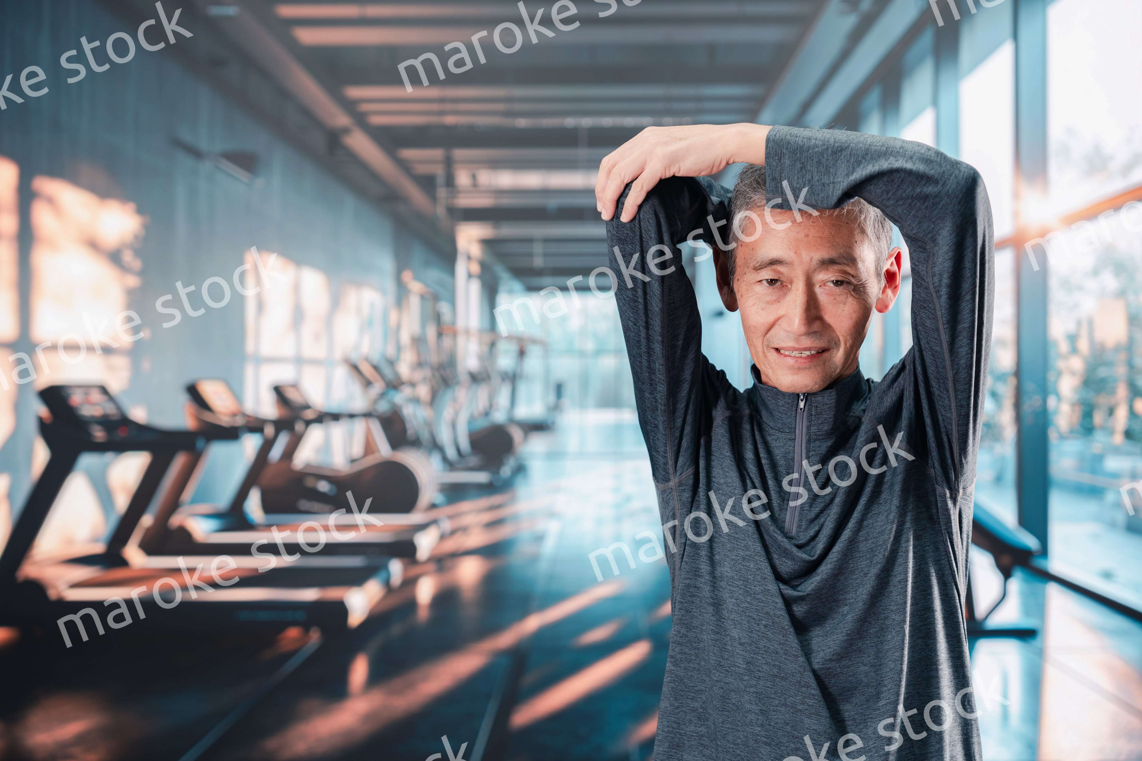 スポーツジムで運動をするシニアの男性