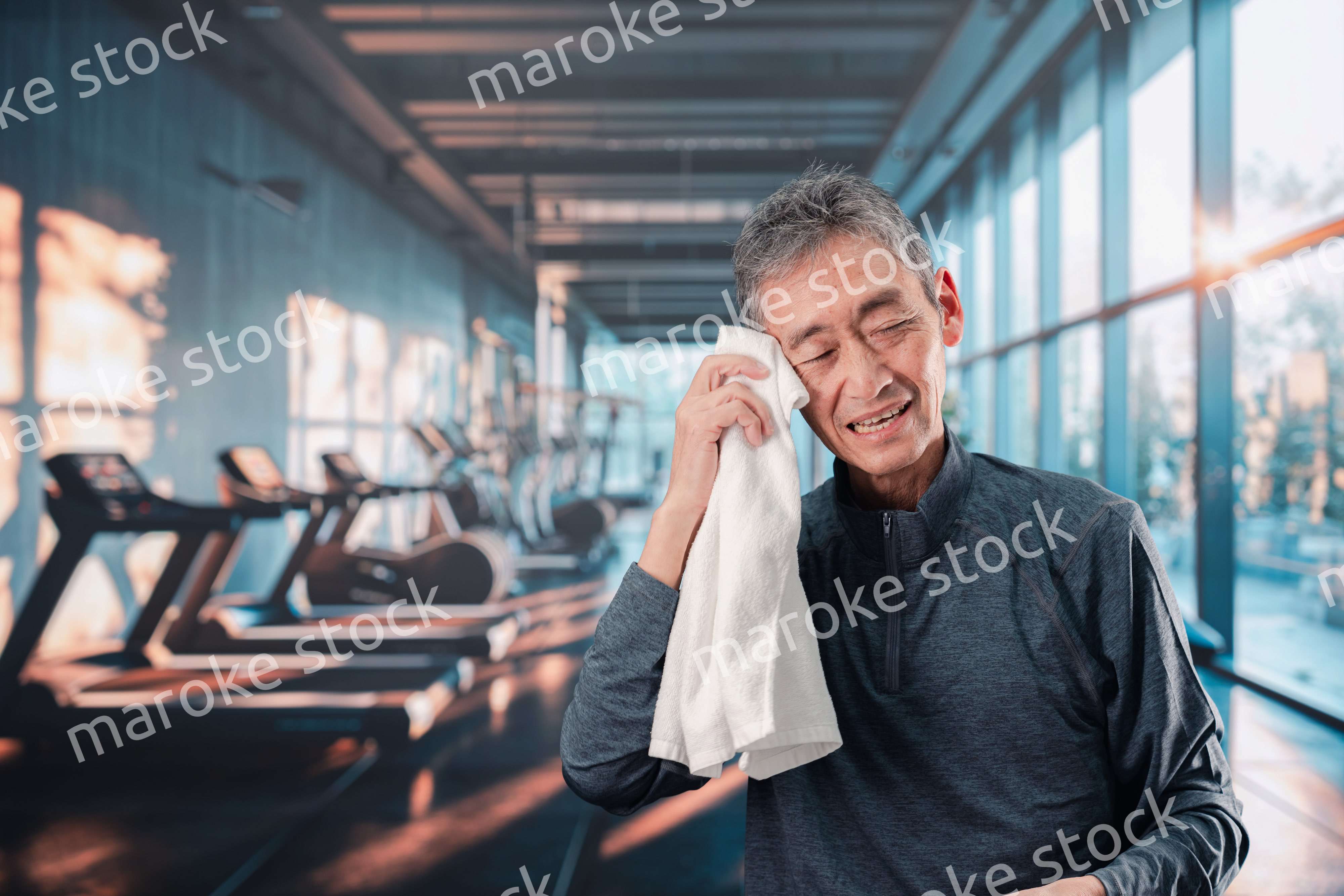 スポーツジムで運動をするシニアの男性