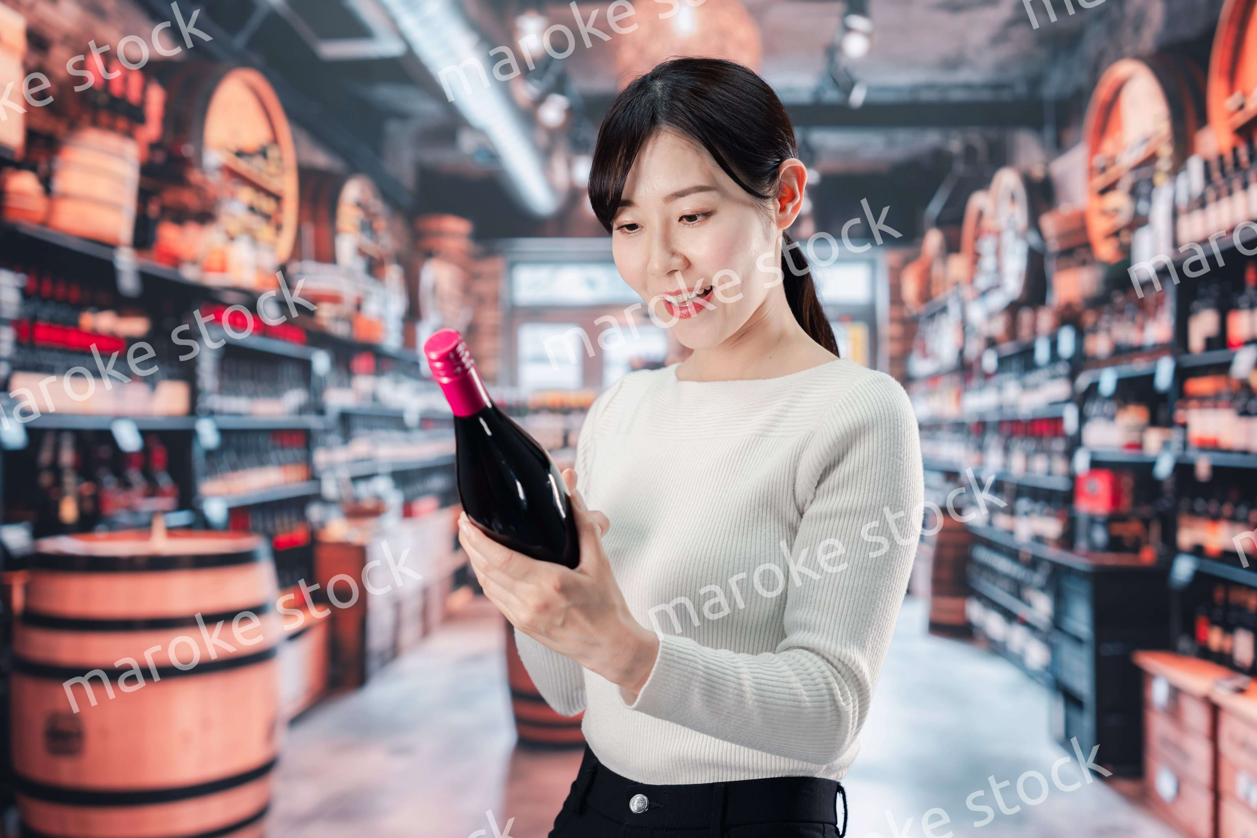 ワインショップでワインを選ぶ若い女性