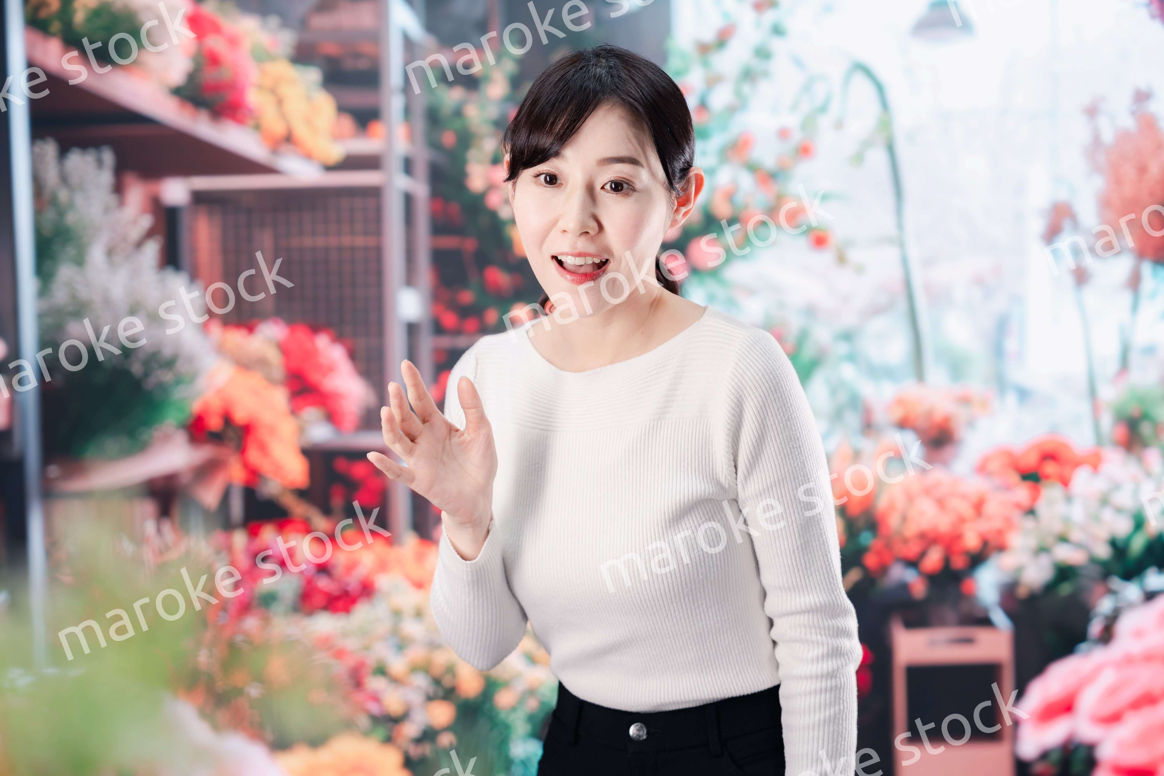 お花屋さんで花を選ぶ若い女性