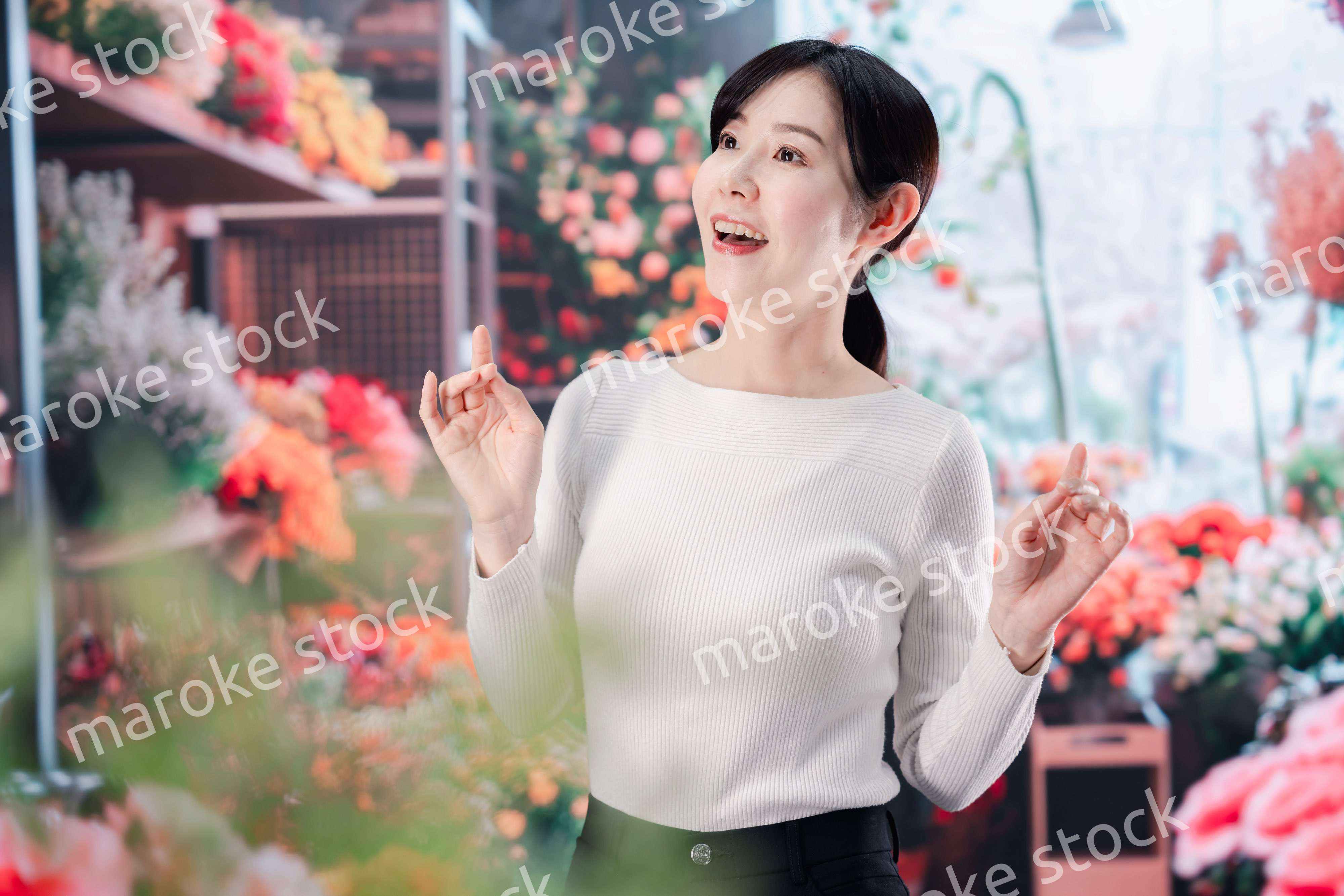 お花屋さんで花を選ぶ若い女性