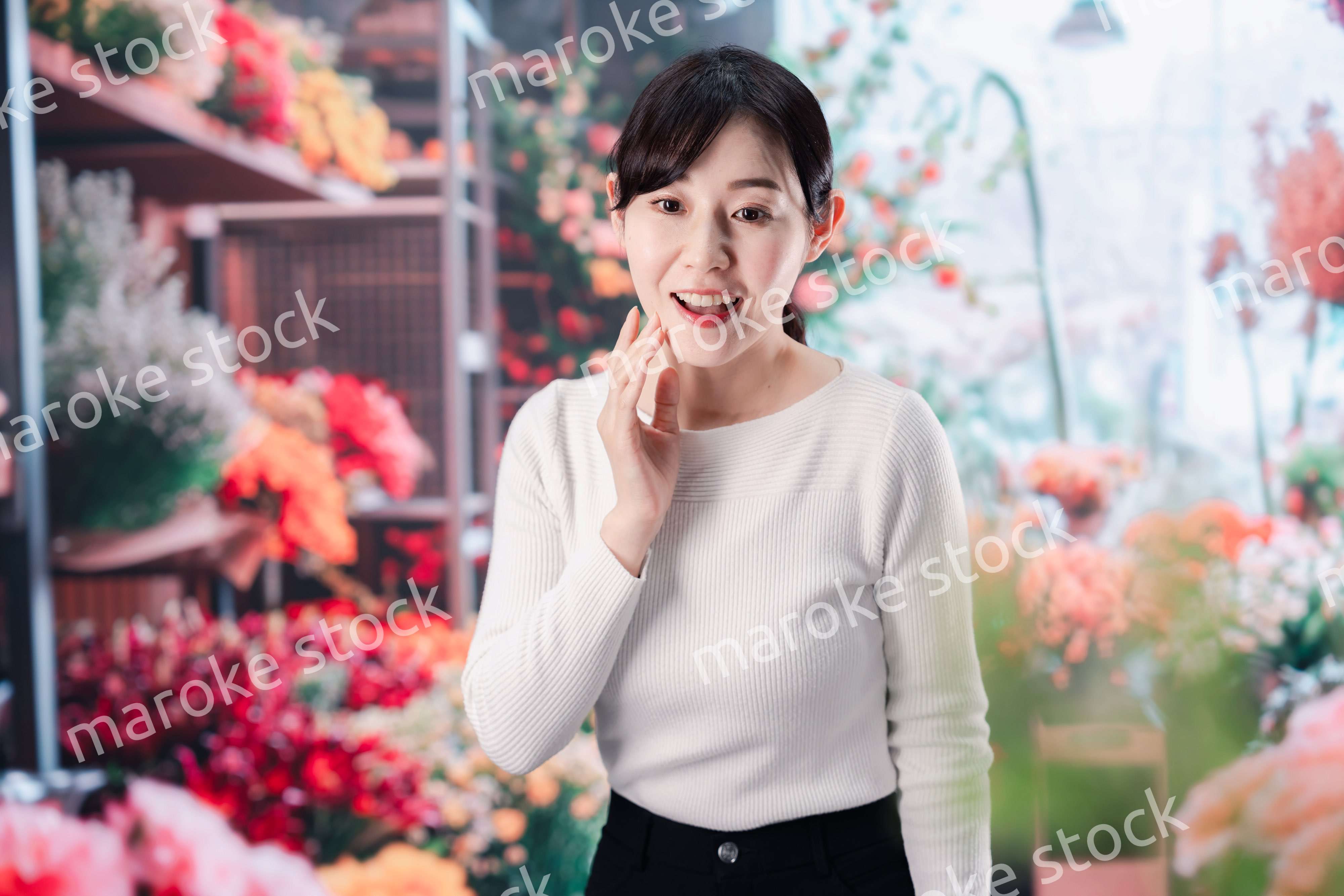 お花屋さんで花を選ぶ若い女性