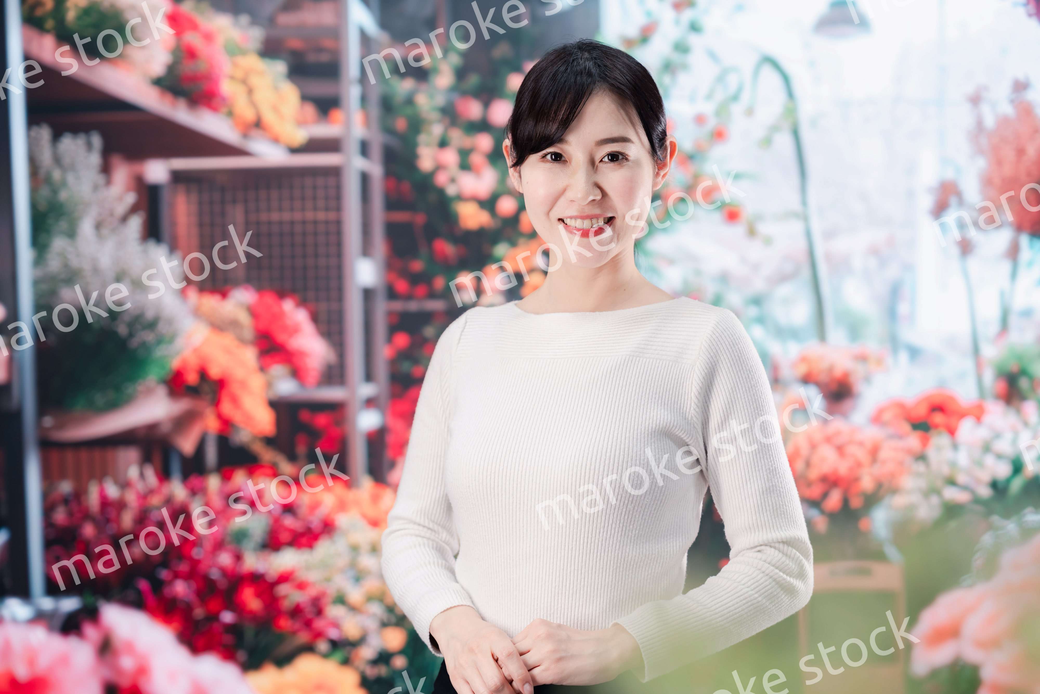 お花屋さんで花を選ぶ若い女性